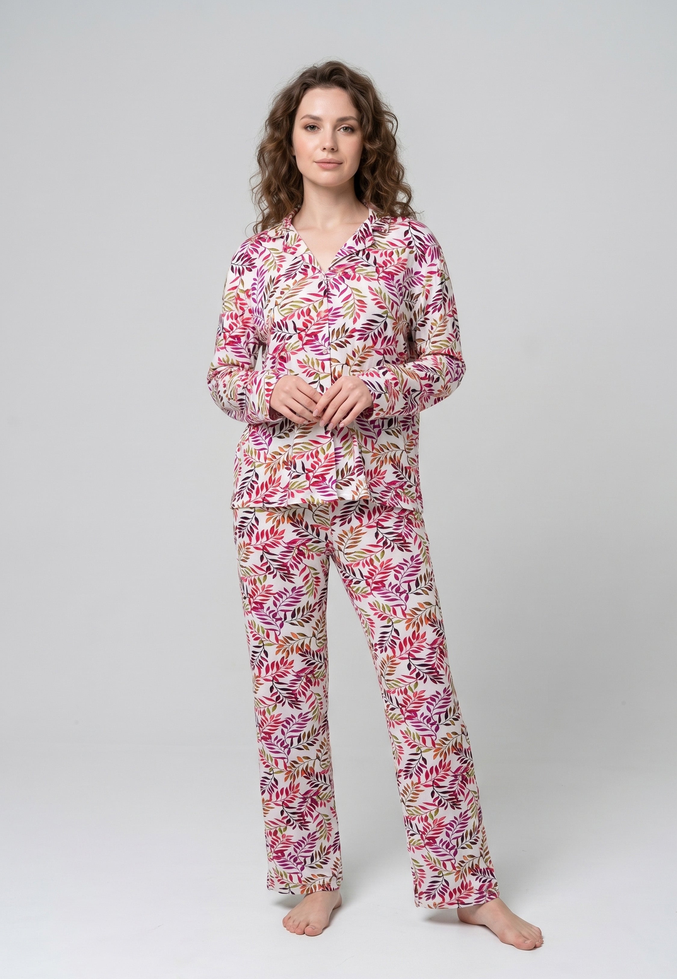 Femme portant un pyjama deux pièces chemise boutonnée col pyjama manches longues imprimé feuillage multicolore rose rouge et doré et pantalon droit assorti Rosabella Soft Bloom