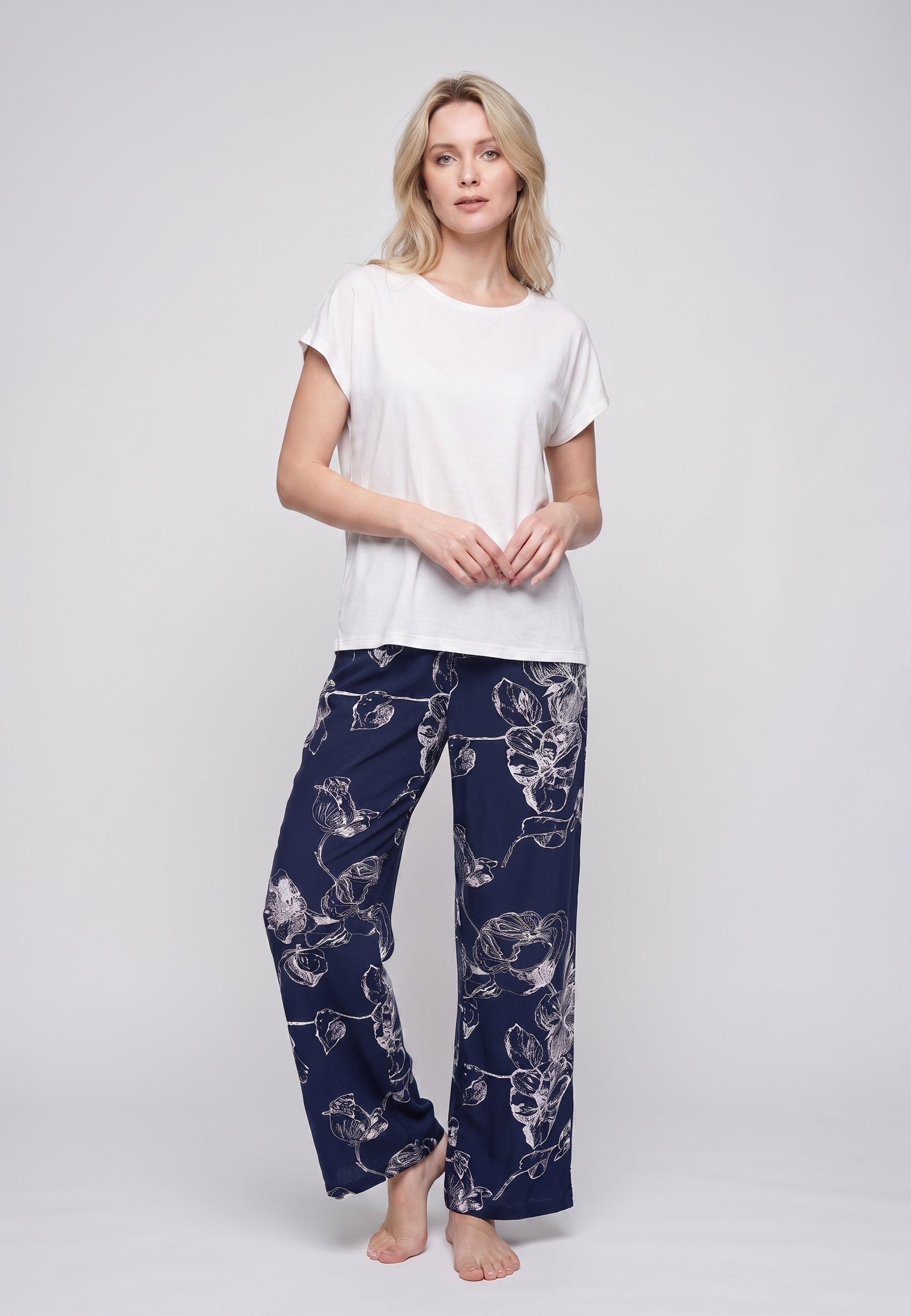 Femme portant un t-shirt écru & pantalon large grandes fleurs écru fond marine Rosabella