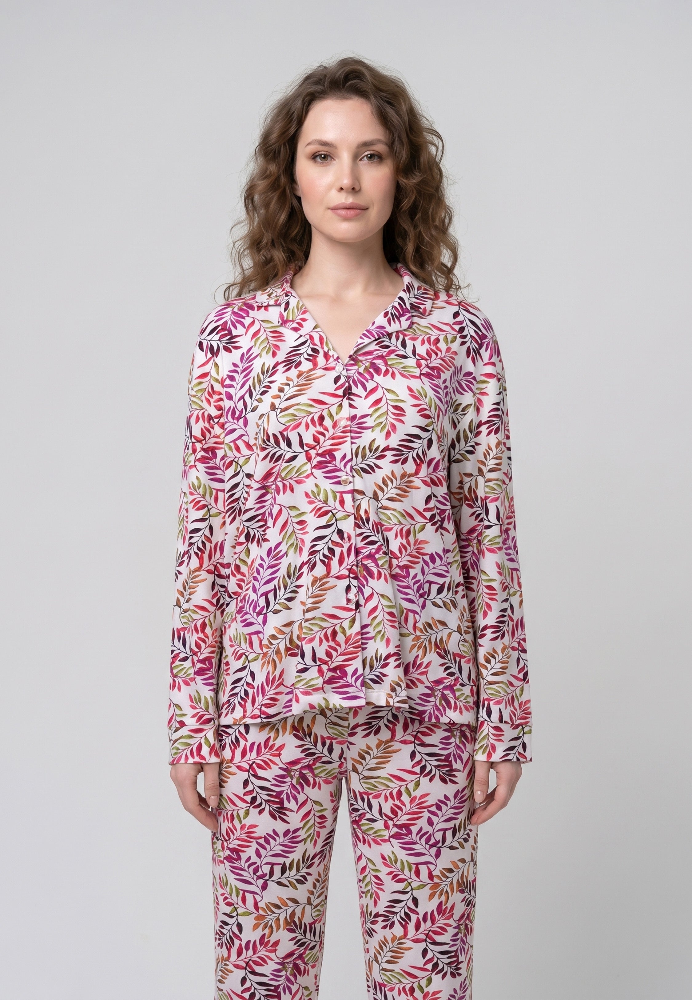 Femme portant un pyjama deux pièces chemise boutonnée col pyjama manches longues imprimé feuillage multicolore rose rouge et doré et pantalon droit assorti Rosabella Soft Bloom