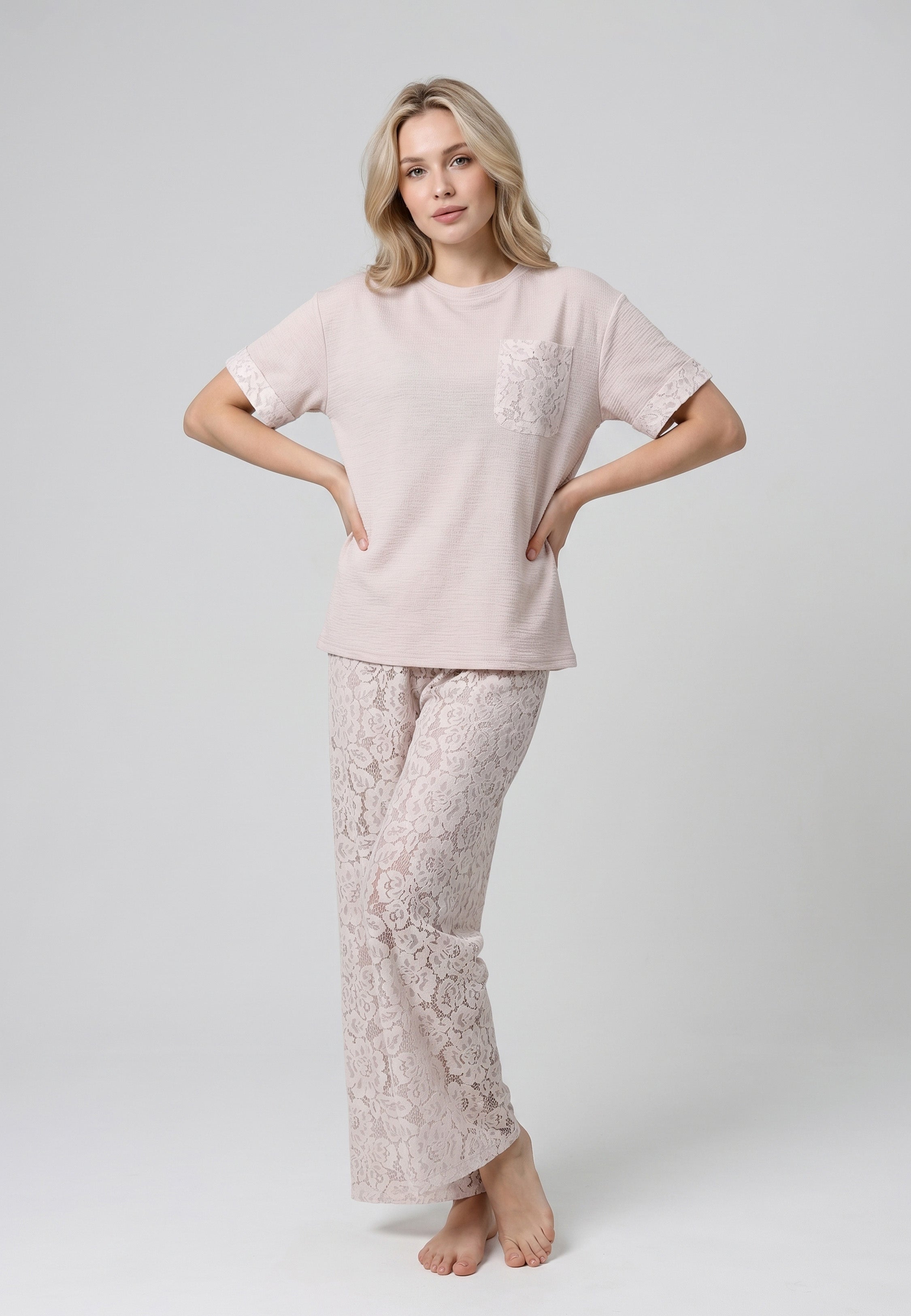 Femme portant un ensemble top col rond texturé rose poudré et pantalon large dentelle florale ajourée rose poudré Rosabella