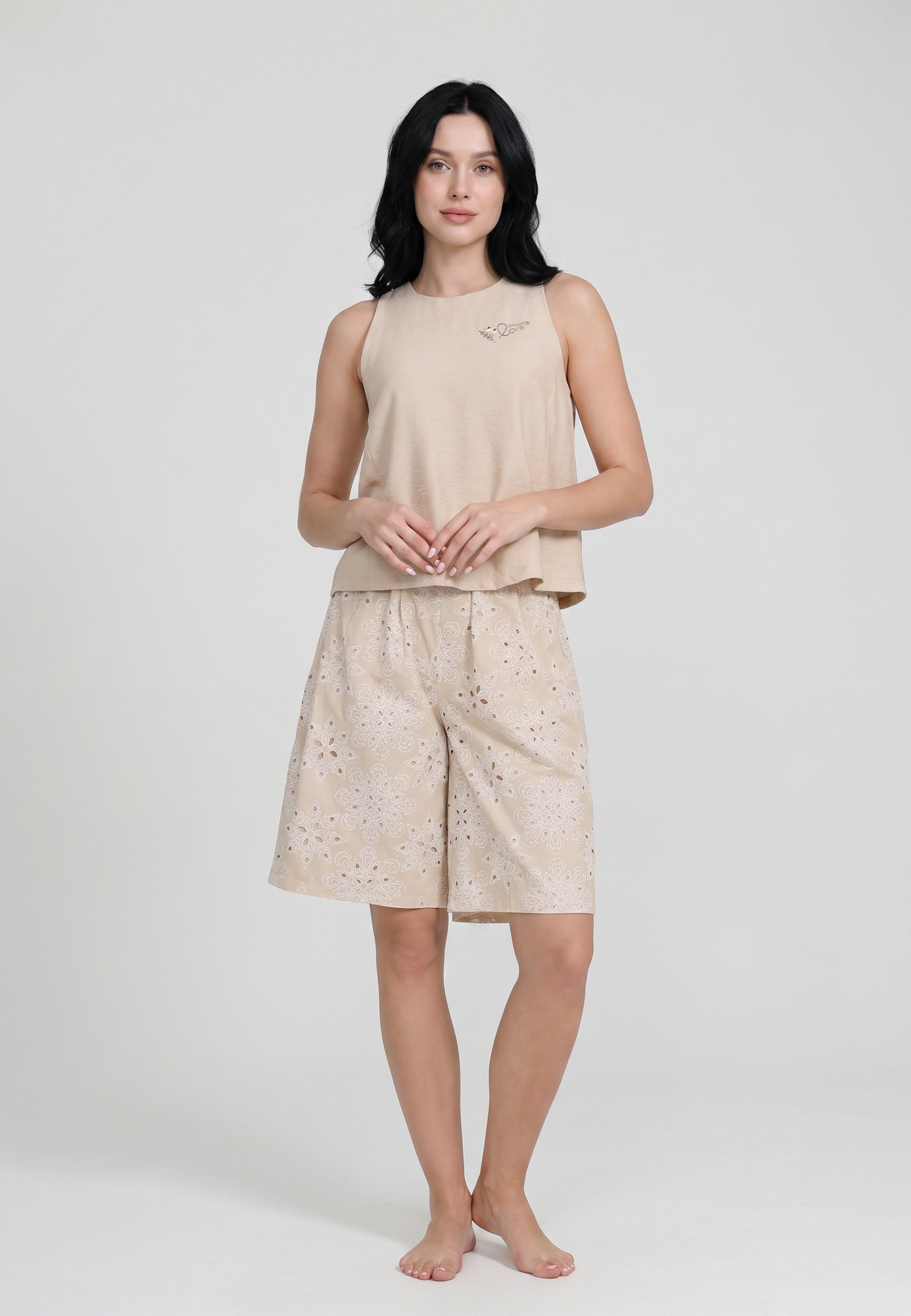 Femme portant un ensemble débardeur sans manches col rond uni sable badge brodé et short large broderie perforée florale sable Rosabella