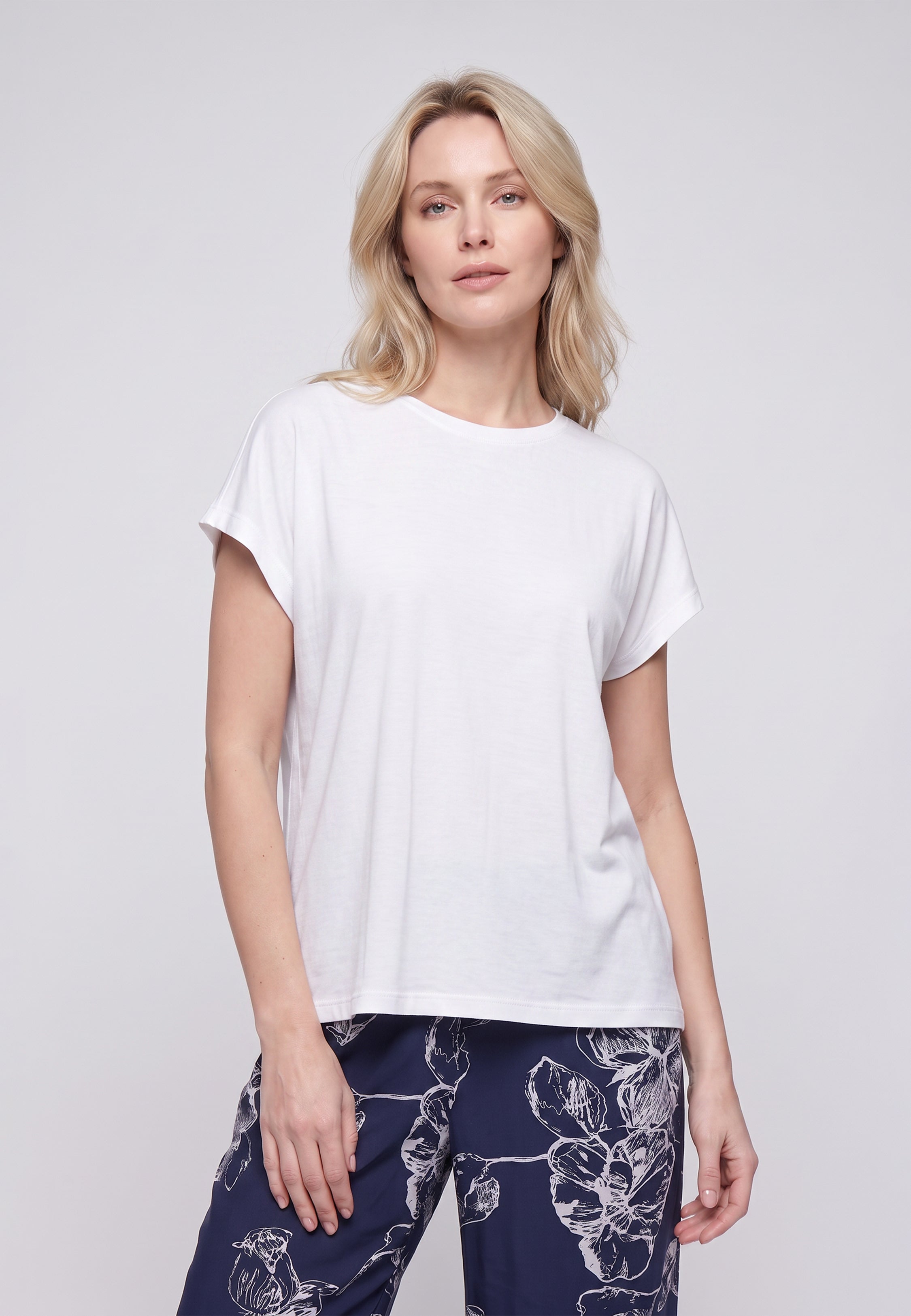 Femme portant un t-shirt écru & pantalon large grandes fleurs écru fond marine Rosabella