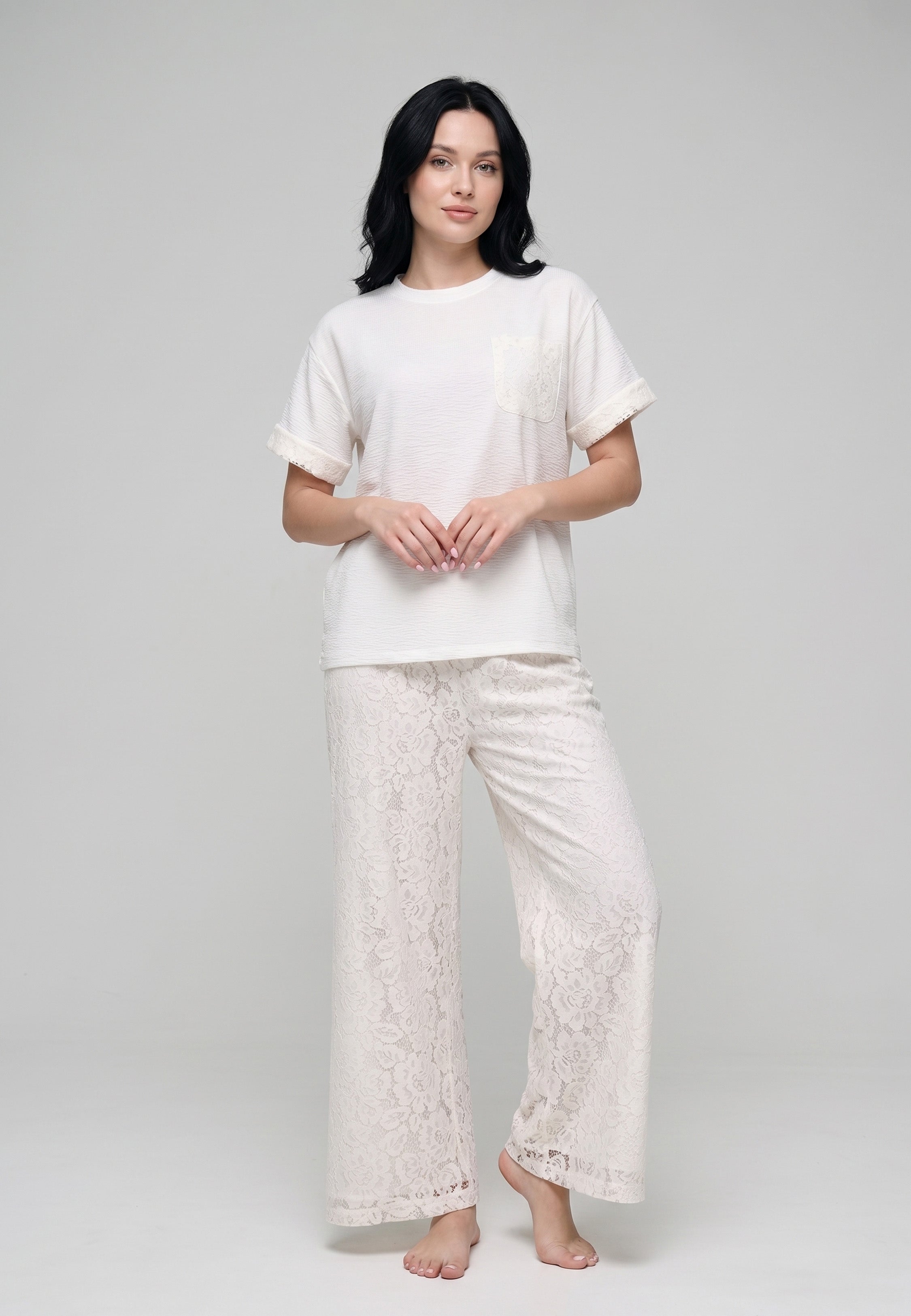 Femme portant un ensemble top col rond texturé ivoire et pantalon large dentelle florale ajourée ivoire Rosabella