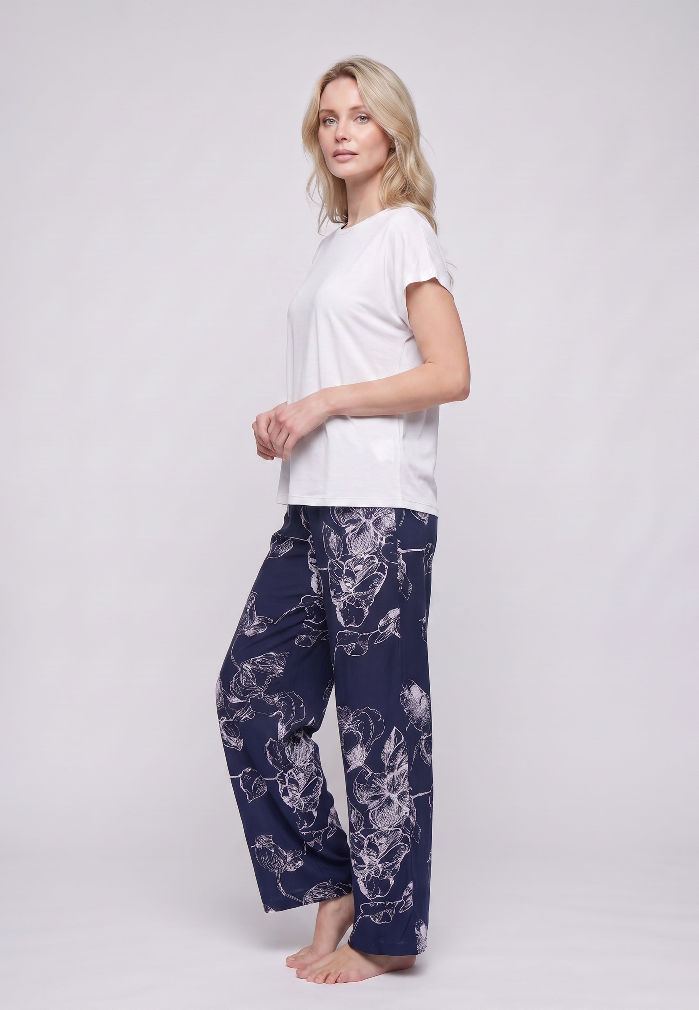 Femme portant un t-shirt écru & pantalon large grandes fleurs écru fond marine Rosabella
