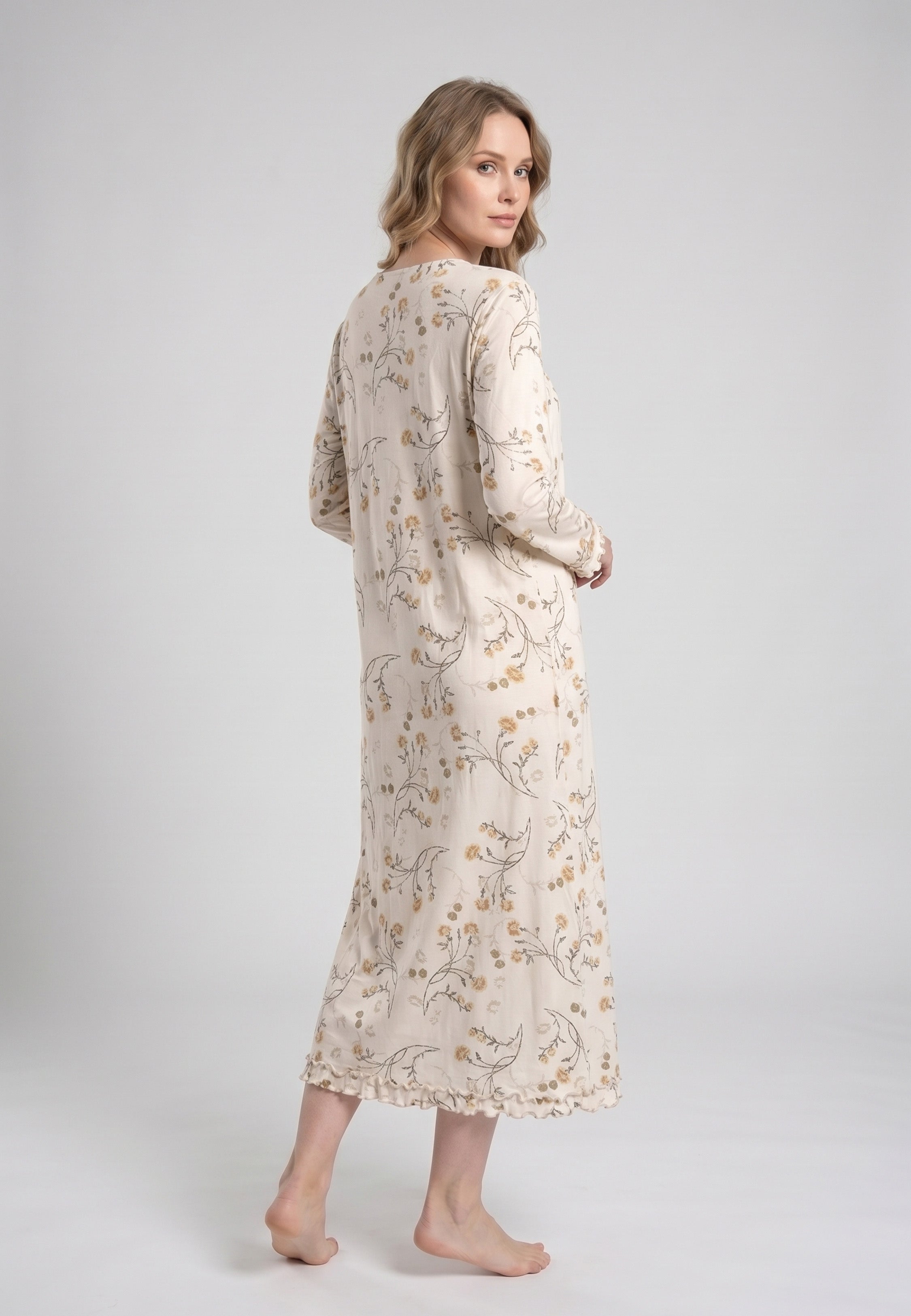 Femme portant une robe de nuit longue col rond boutonné manches longues festonnées imprimé fleuri fleurs sauvages beige et doré sur fond crème Rosabella Soft Bloom