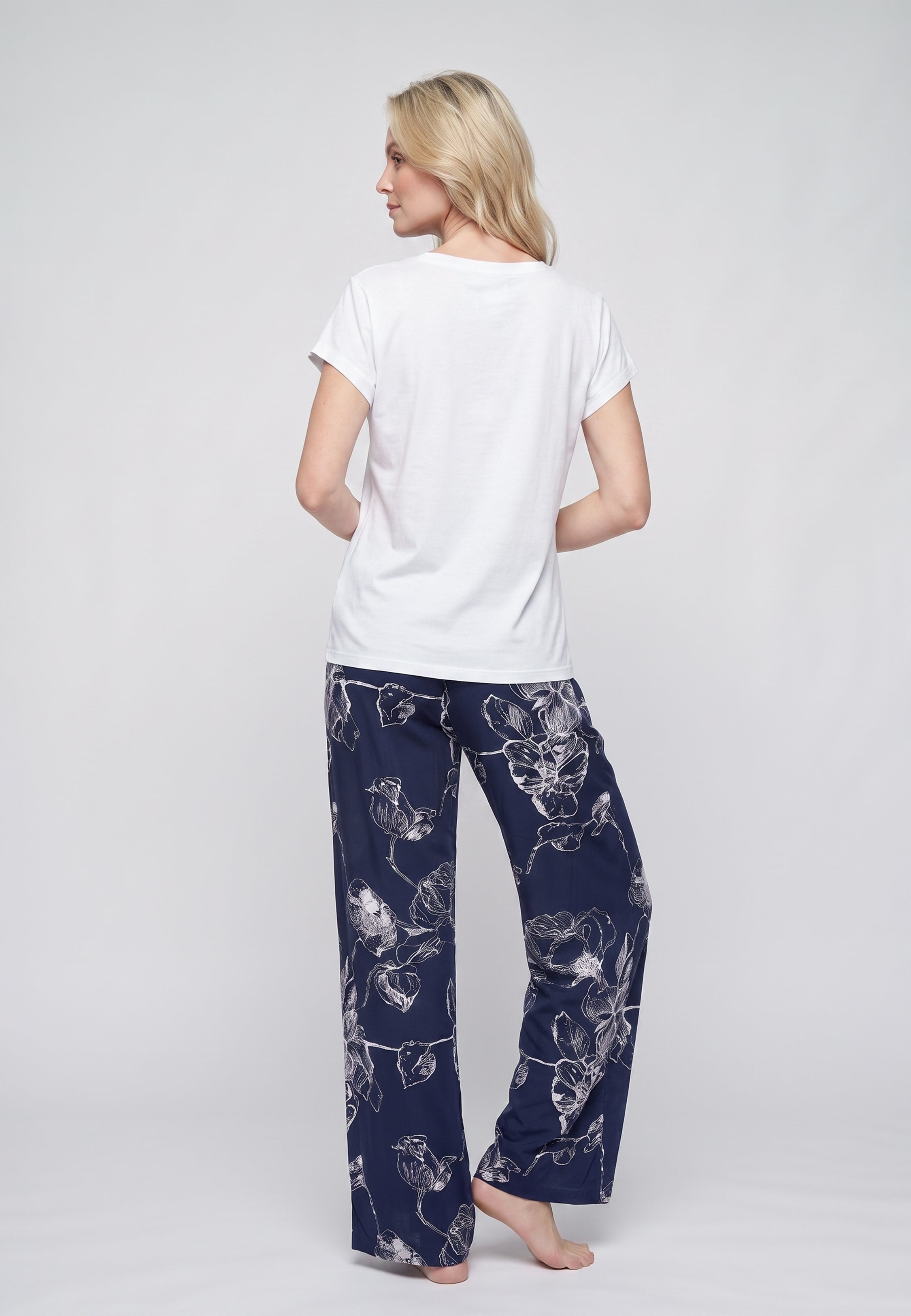 Femme portant un t-shirt écru & pantalon large grandes fleurs écru fond marine Rosabella
