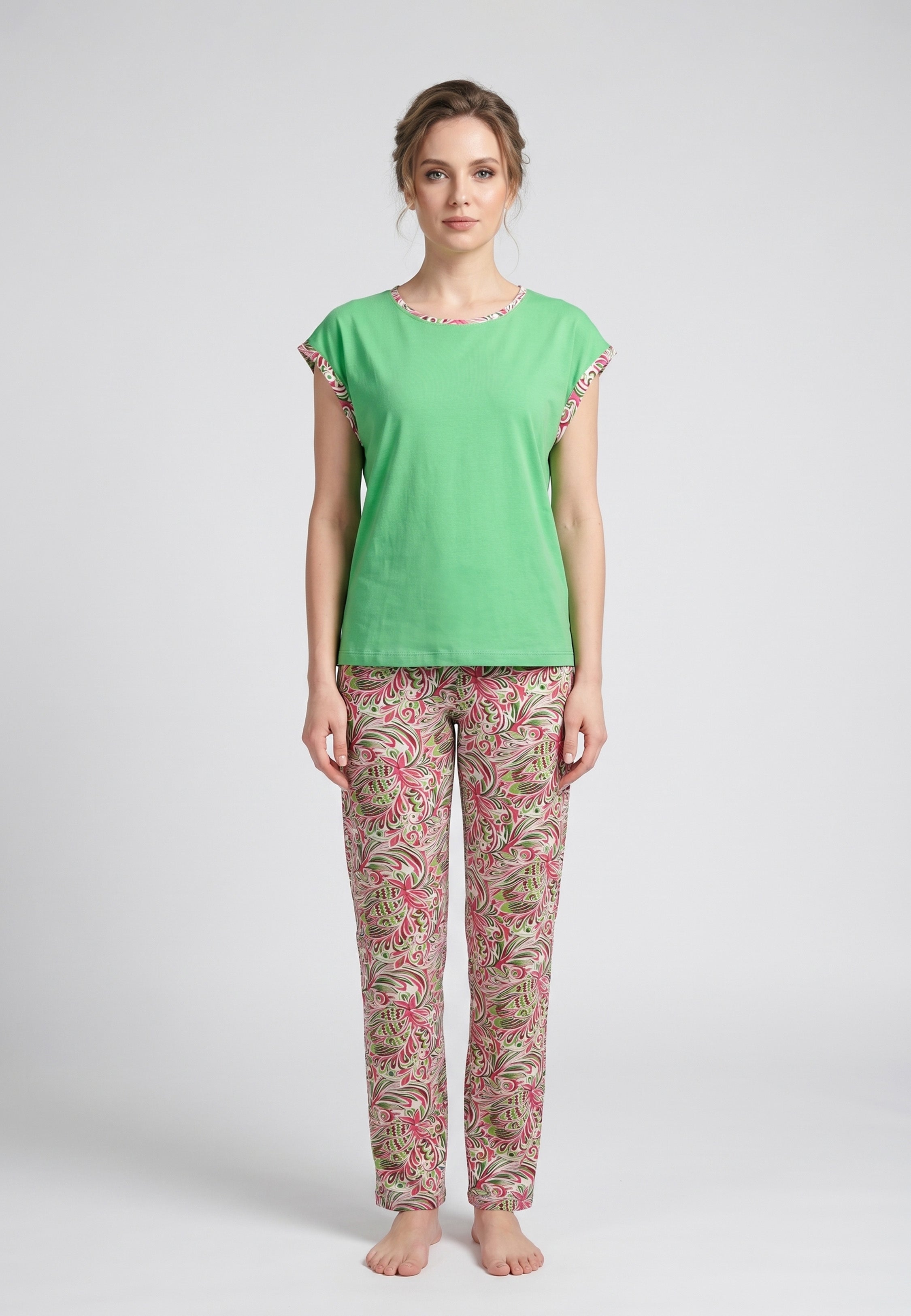Femme portant un pyjama deux pièces t-shirt vert clair liseré fleuri au col et manches et pantalon long imprimé aquarelle fleuri multicolore Rosabella Rosalinda