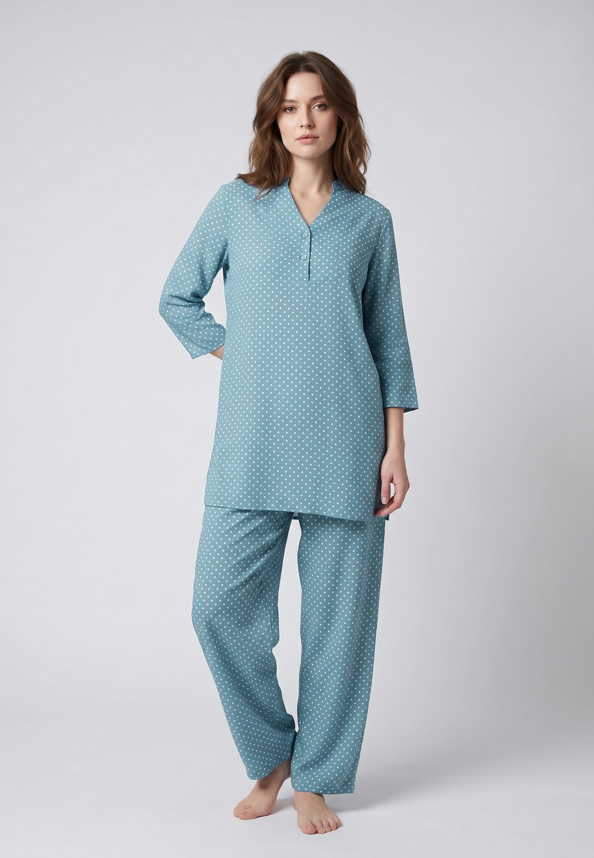 Femme portant un pyjama deux pièces bleu canard à imprimé pois blancs