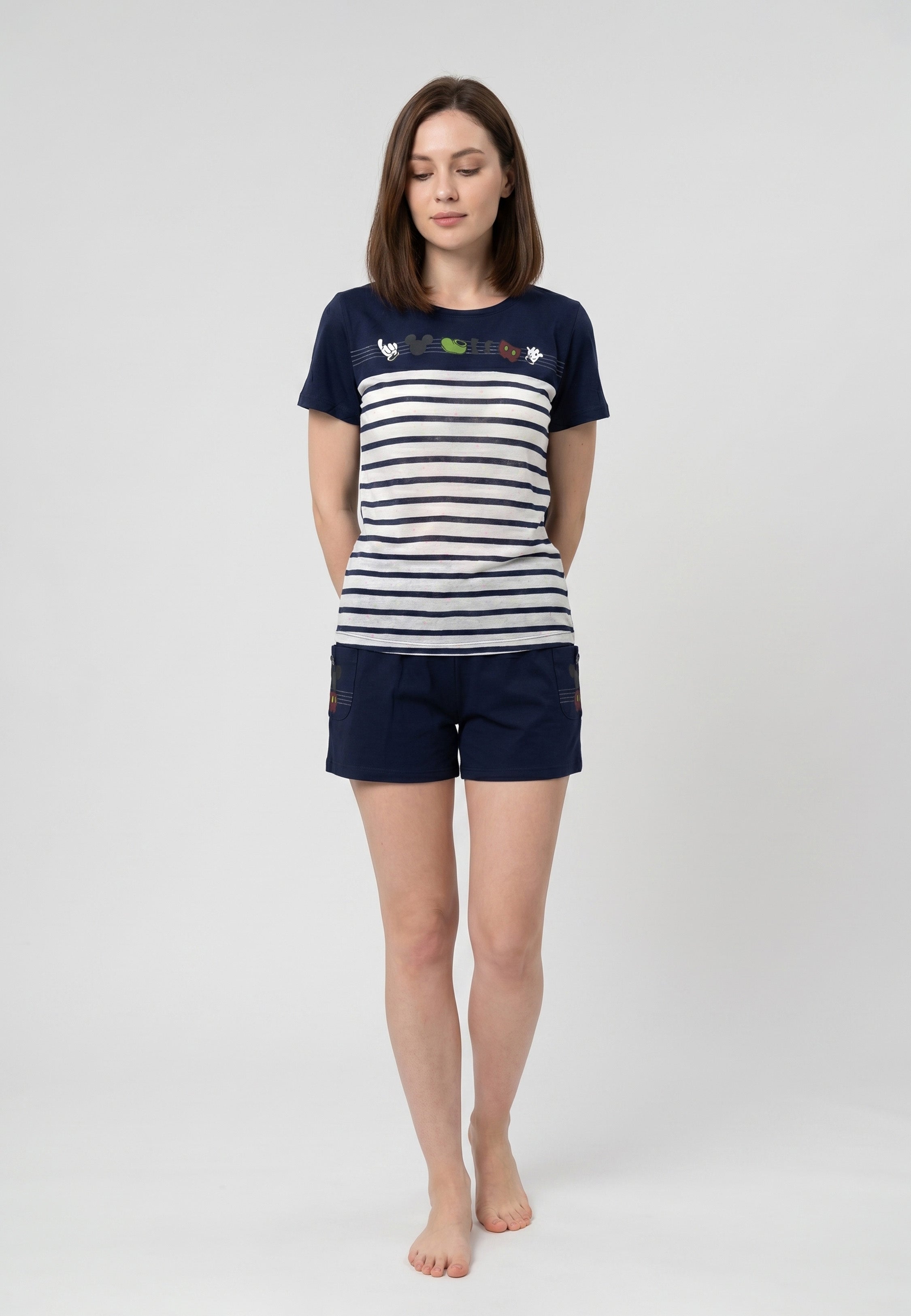 Femme portant un pyjama deux pièces rayé marine avec mini imprimés Mickey Icons et short uni bleu marine avec poches