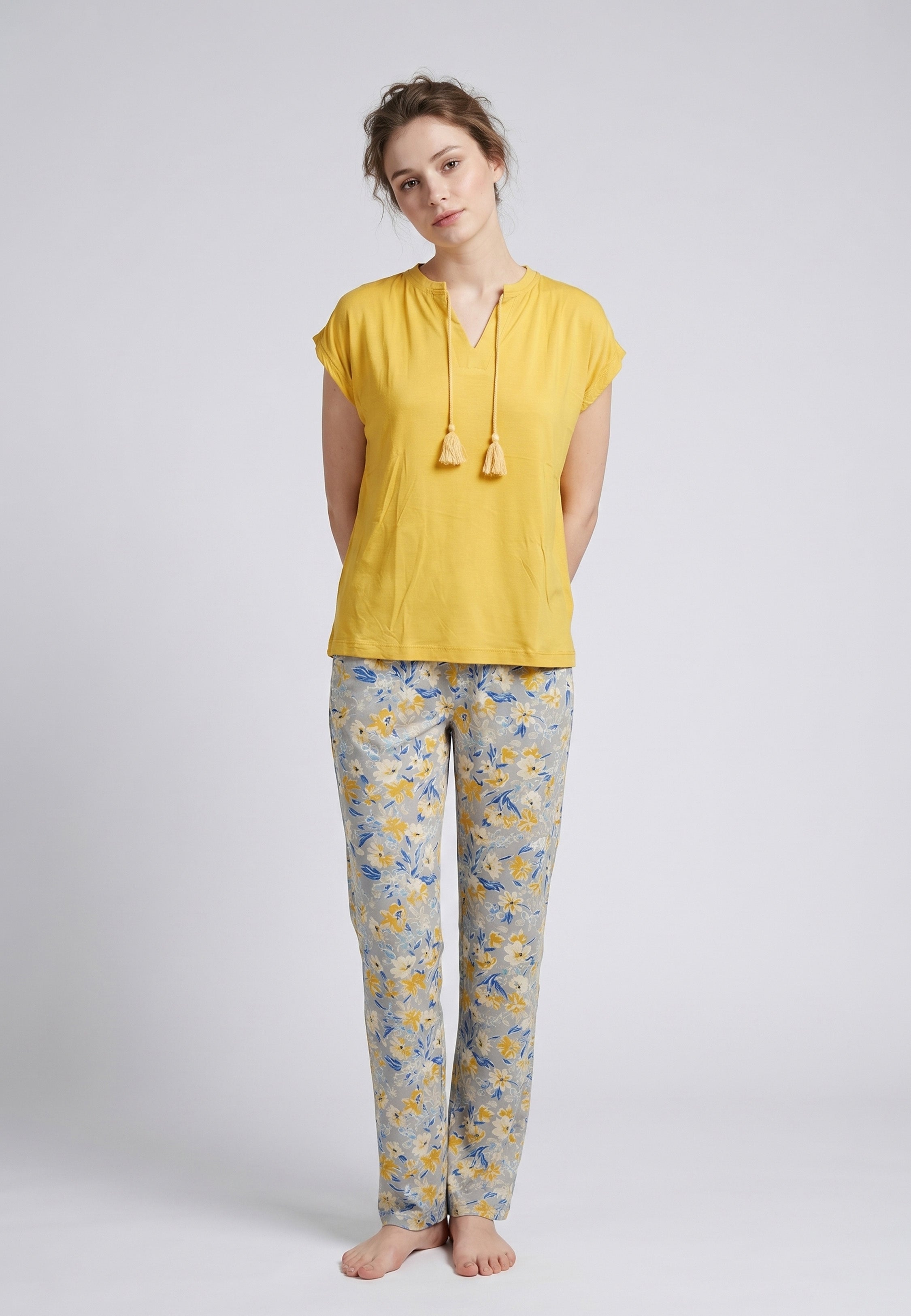 Femme portant un pyjama deux pièces top moutarde col V avec lacets pompons et pantalon long imprimé ethnique floral multicolore Rosabella Ethnique 2