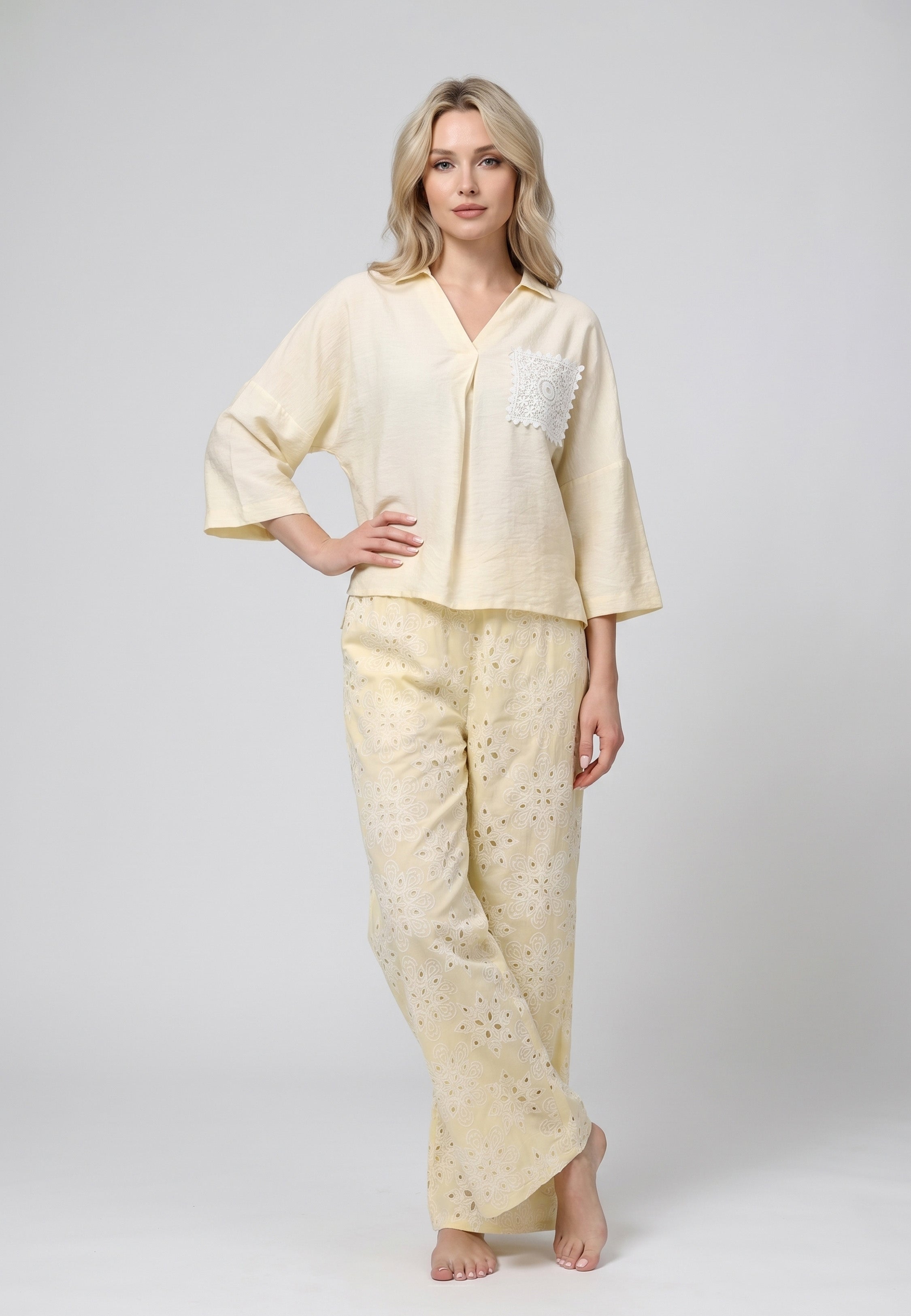 Femme portant un ensemble top col camp uni jaune pâle poche broderie perforée blanche et pantalon large broderie perforée florale jaune pâle Rosabella