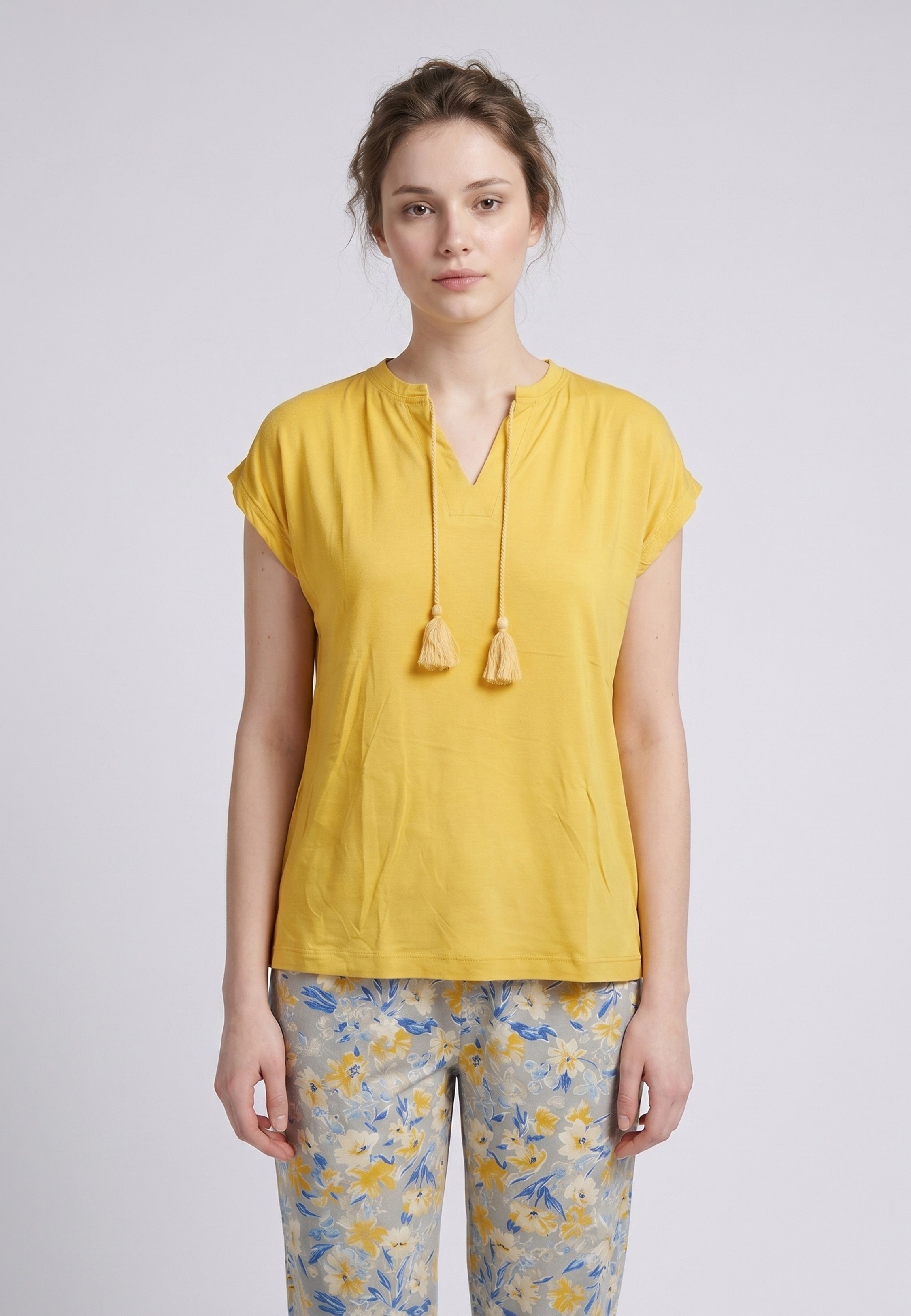 Femme portant un pyjama deux pièces top moutarde col V avec lacets pompons et pantalon long imprimé ethnique floral multicolore Rosabella Ethnique 2