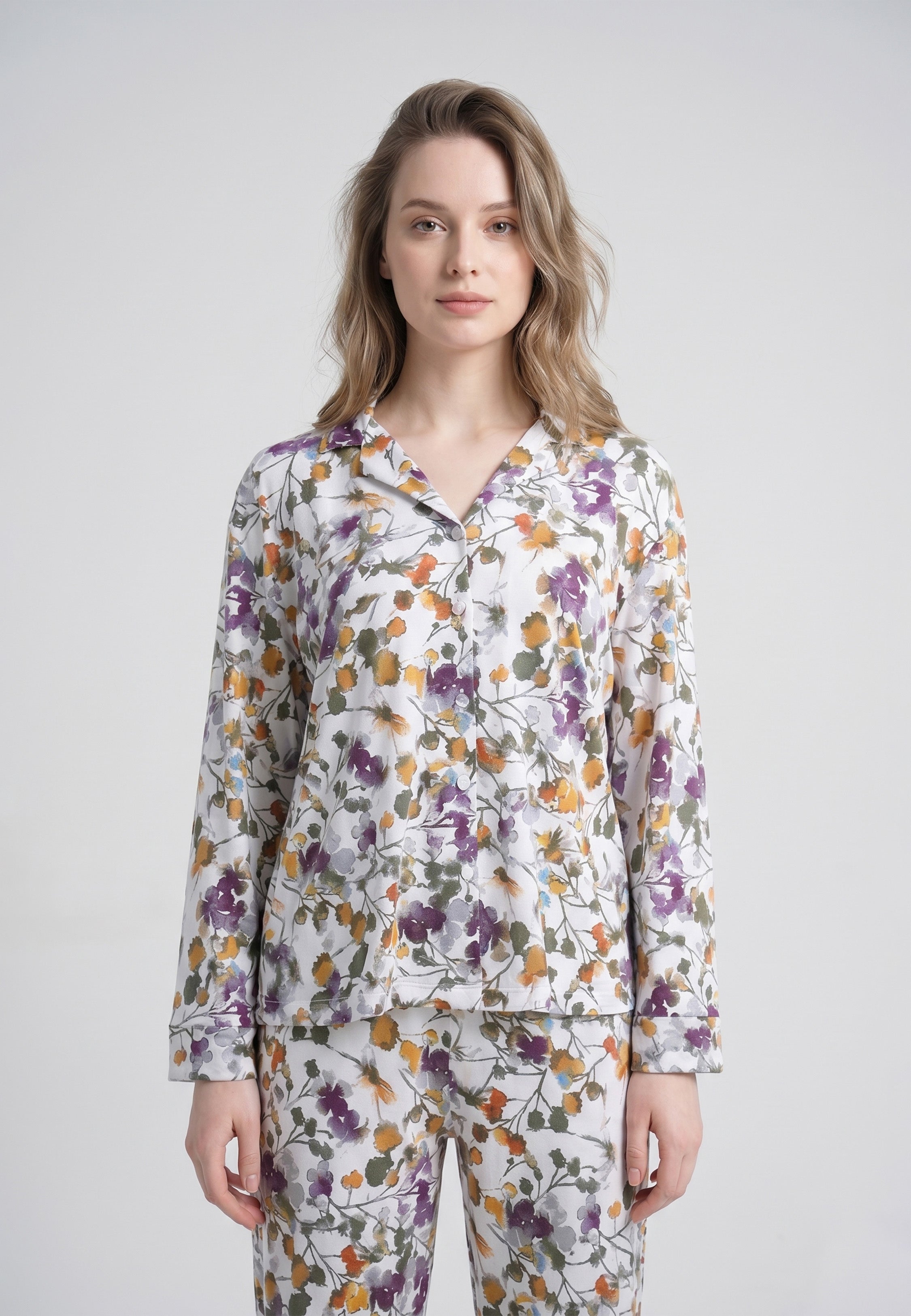 Femme portant un pyjama deux pièces chemise boutonnée col pyjama manches longues imprimé fleuri multicolore mauve orangé et kaki et pantalon droit assorti Rosabella Soft Bloom