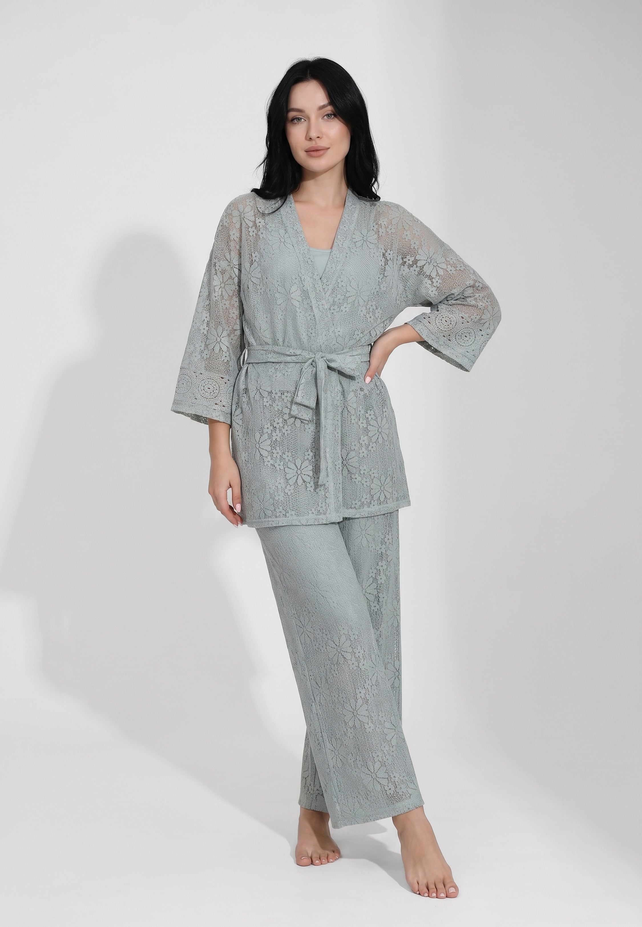 Femme portant un ensemble débardeur col rond bretelles larges bleu acier et pantalon large dentelle florale transparente motif marguerites Rosabella