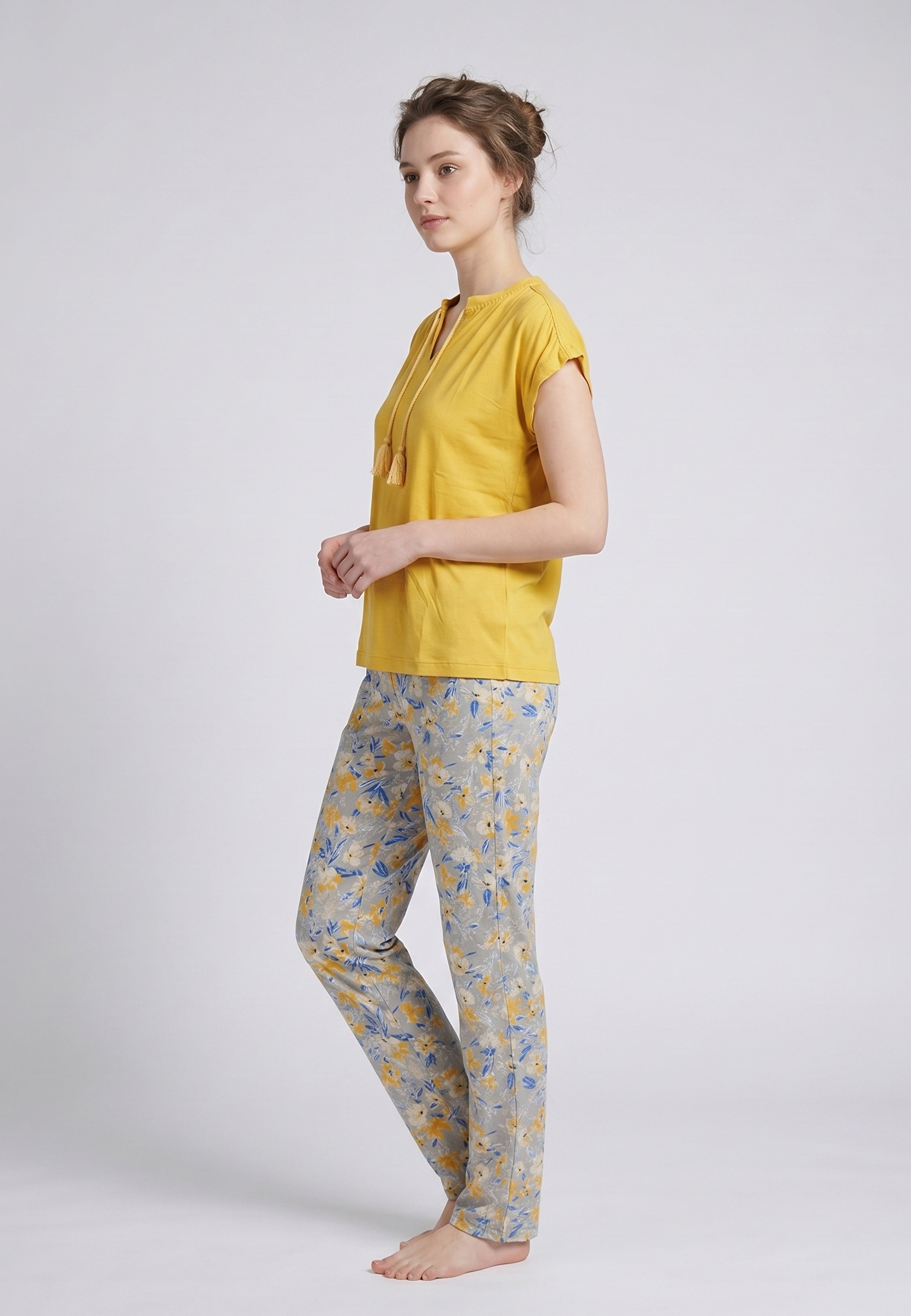 Femme portant un pyjama deux pièces top moutarde col V avec lacets pompons et pantalon long imprimé ethnique floral multicolore Rosabella Ethnique 2