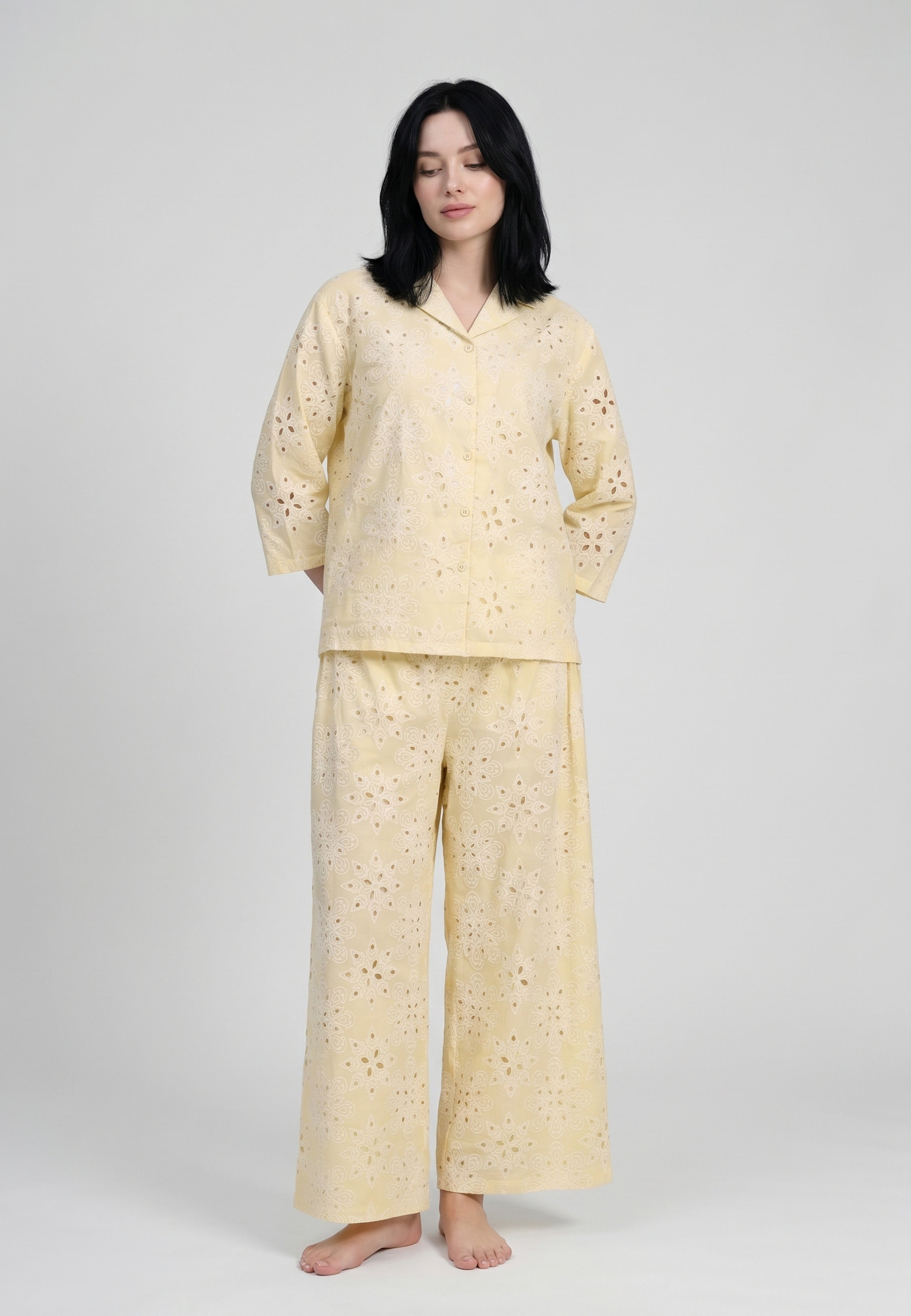 Femme portant un ensemble chemise col réver boutonnée manches 3/4 broderie perforée florale jaune pâle et pantalon large assorti ajouré Rosabella