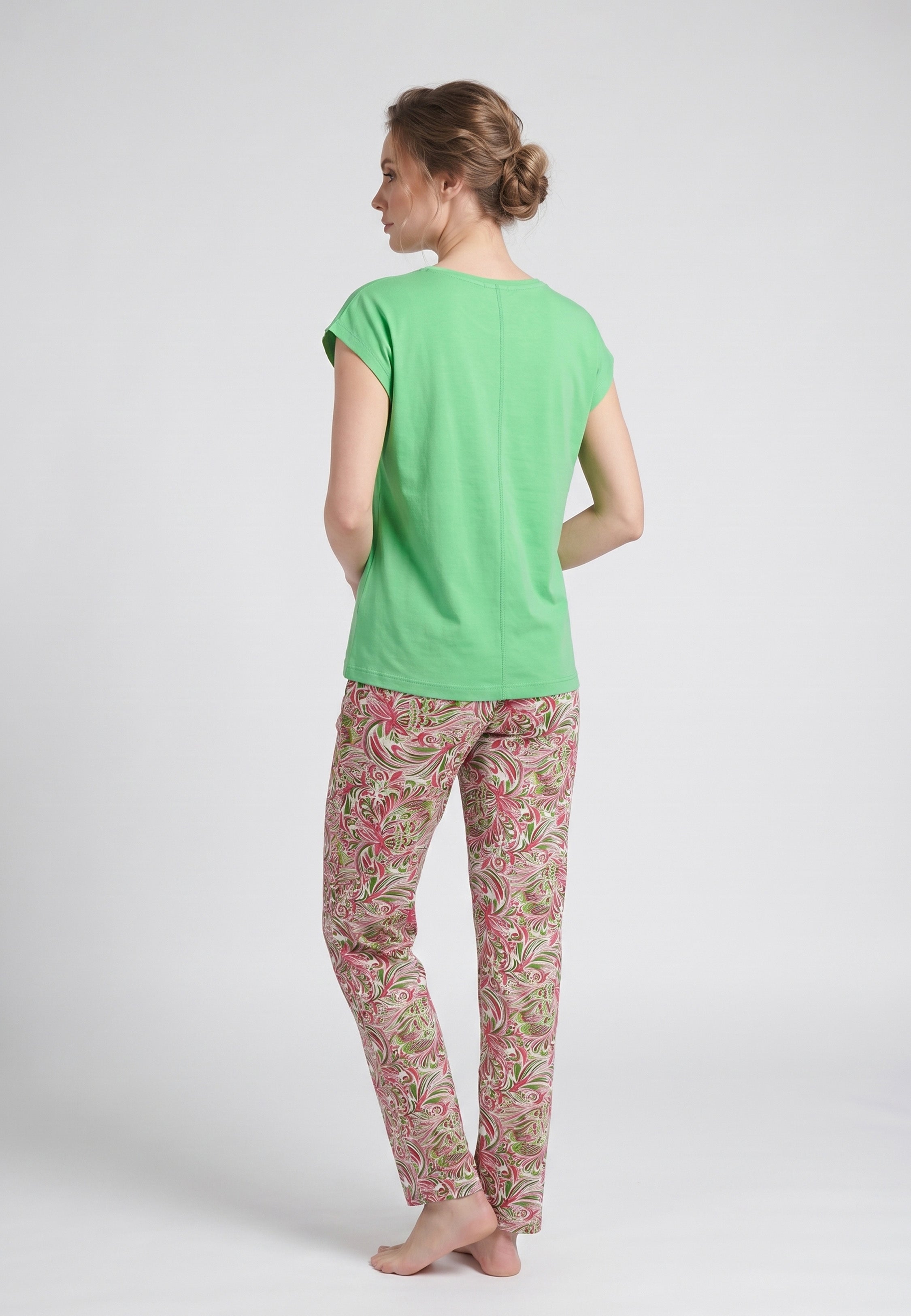 Femme portant un pyjama deux pièces t-shirt vert clair liseré fleuri au col et manches et pantalon long imprimé aquarelle fleuri multicolore Rosabella Rosalinda
