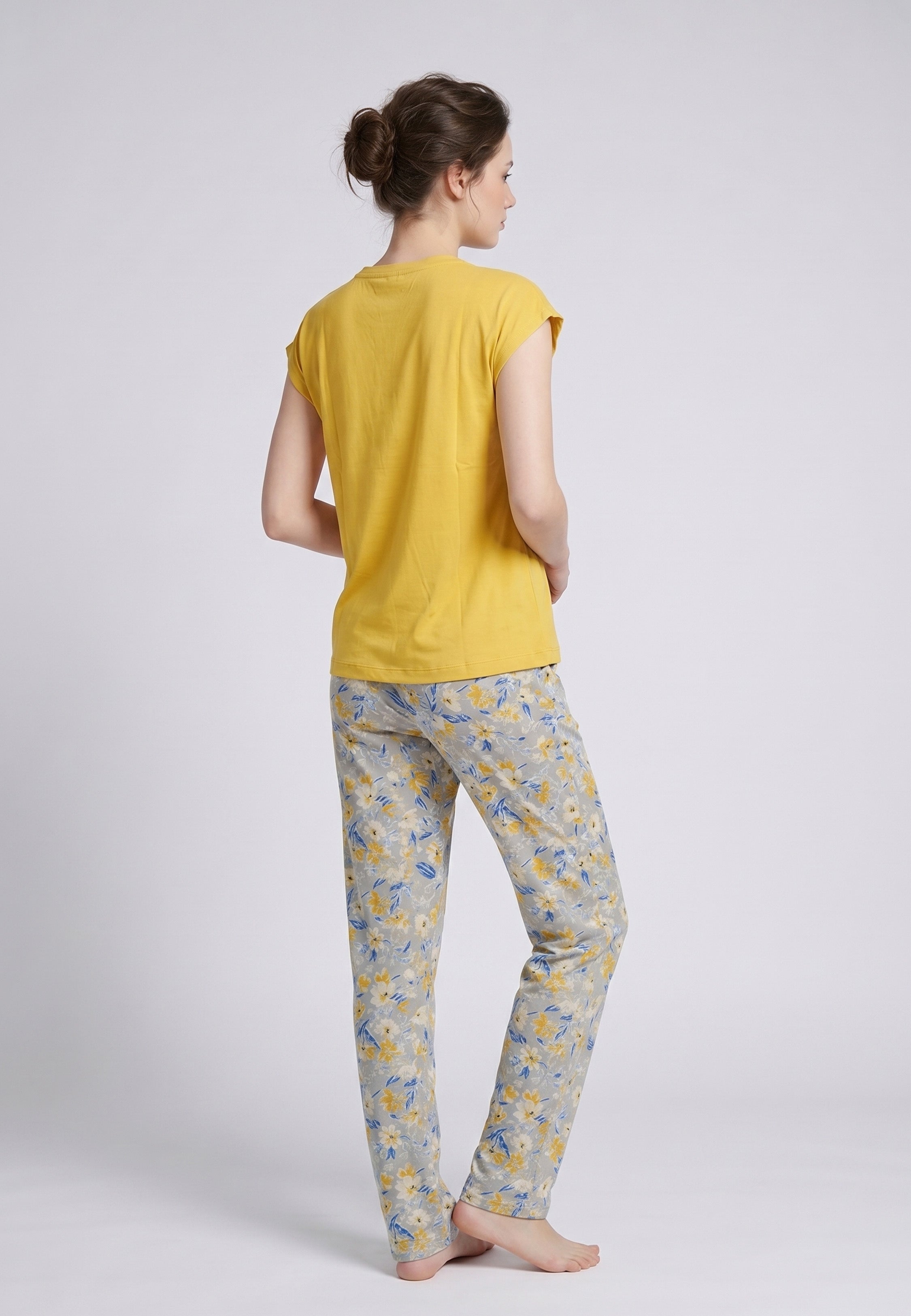 Femme portant un pyjama deux pièces top moutarde col V avec lacets pompons et pantalon long imprimé ethnique floral multicolore Rosabella Ethnique 2