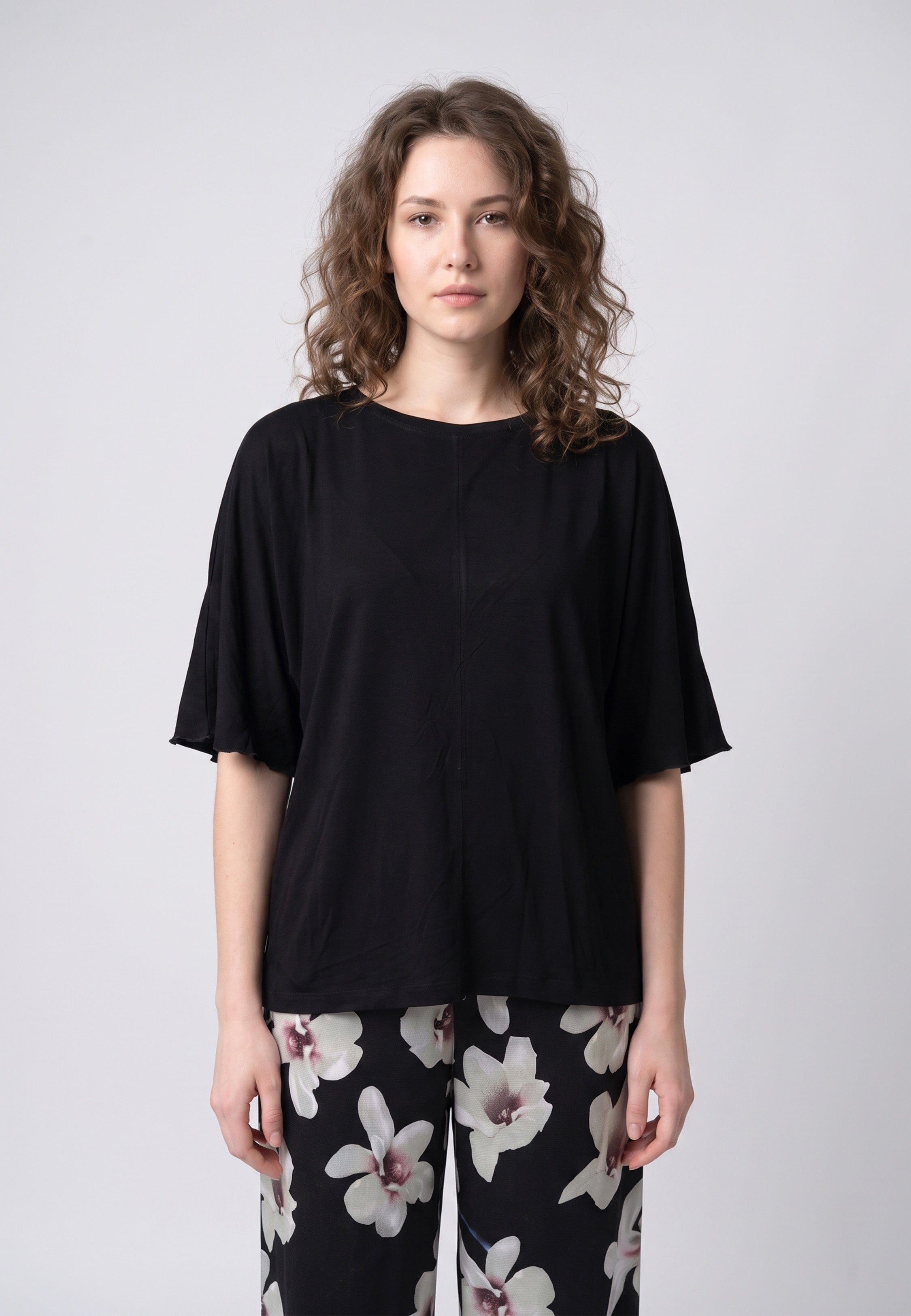 Pyjama pantalon long deux pièces T-shirt col rond noir manches papillon évasées et pantalon large fond noir imprimé grandes orchidées blanc et gris