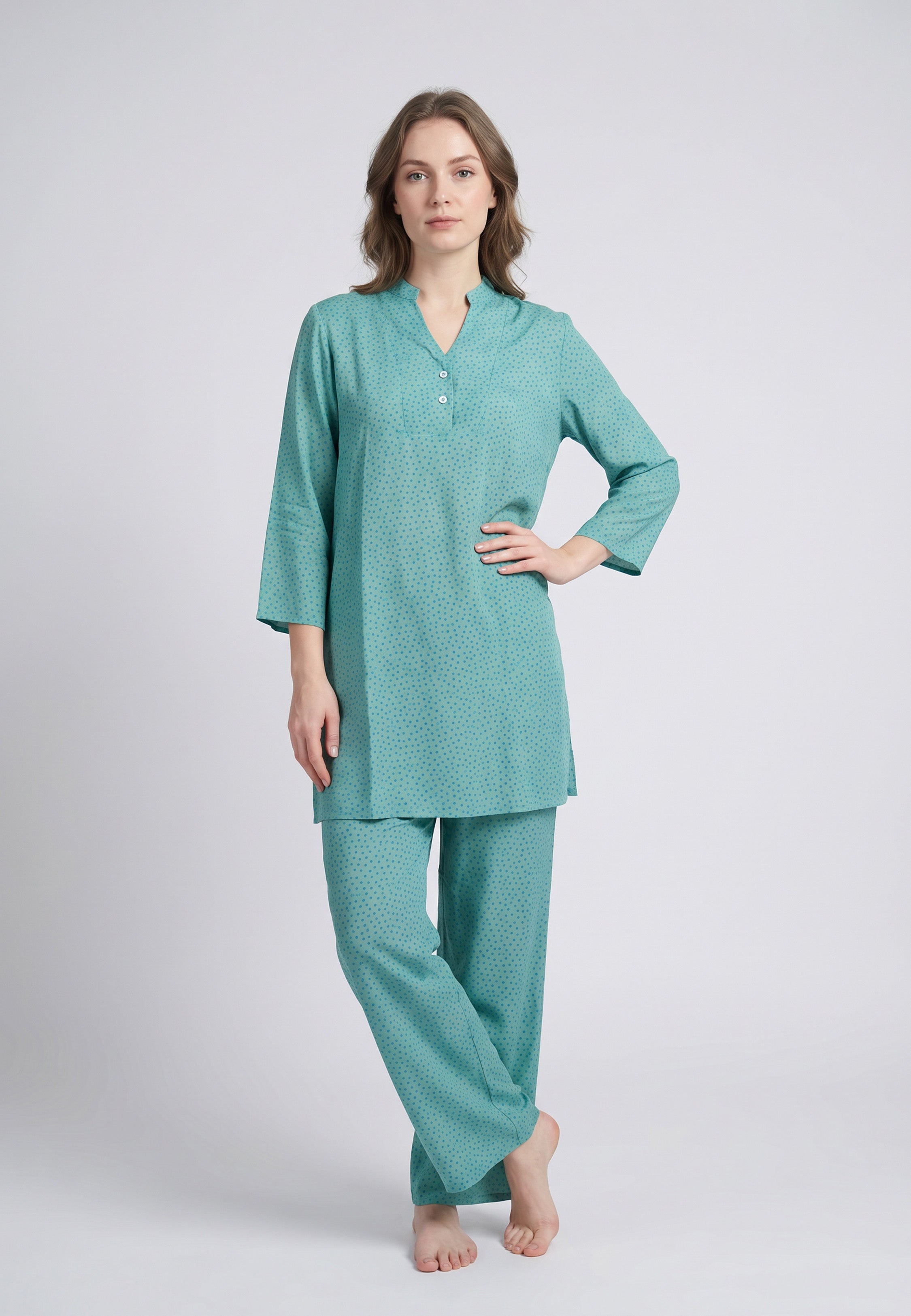 Femme portant un pyjama deux pièces vert à imprimé pois foncés
