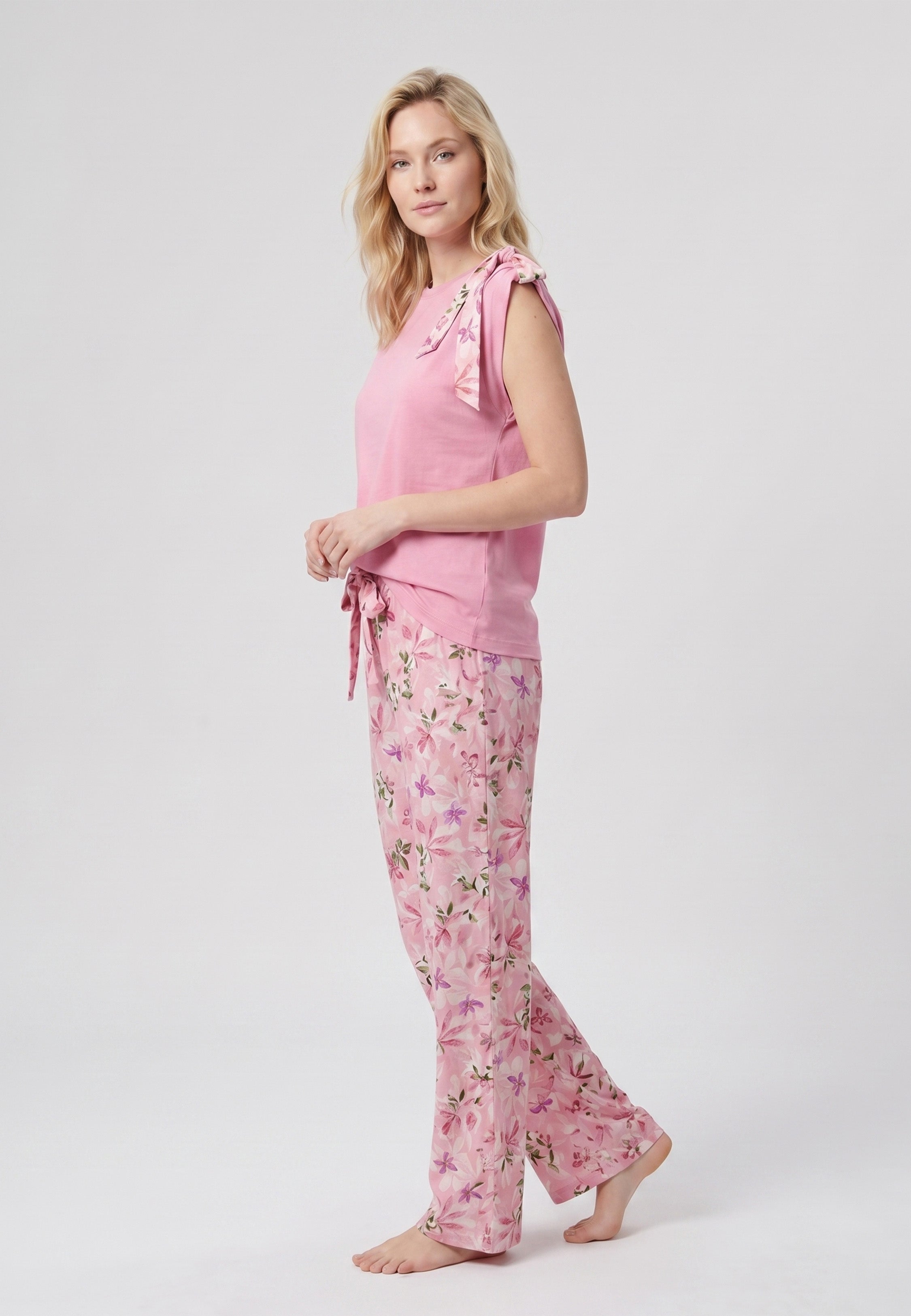 Femme portant un pyjama deux pièces débardeur rose foncé nœud épaule et pantalon long grand imprimé fleuri multicolore Rosabella Rosalinda 2
