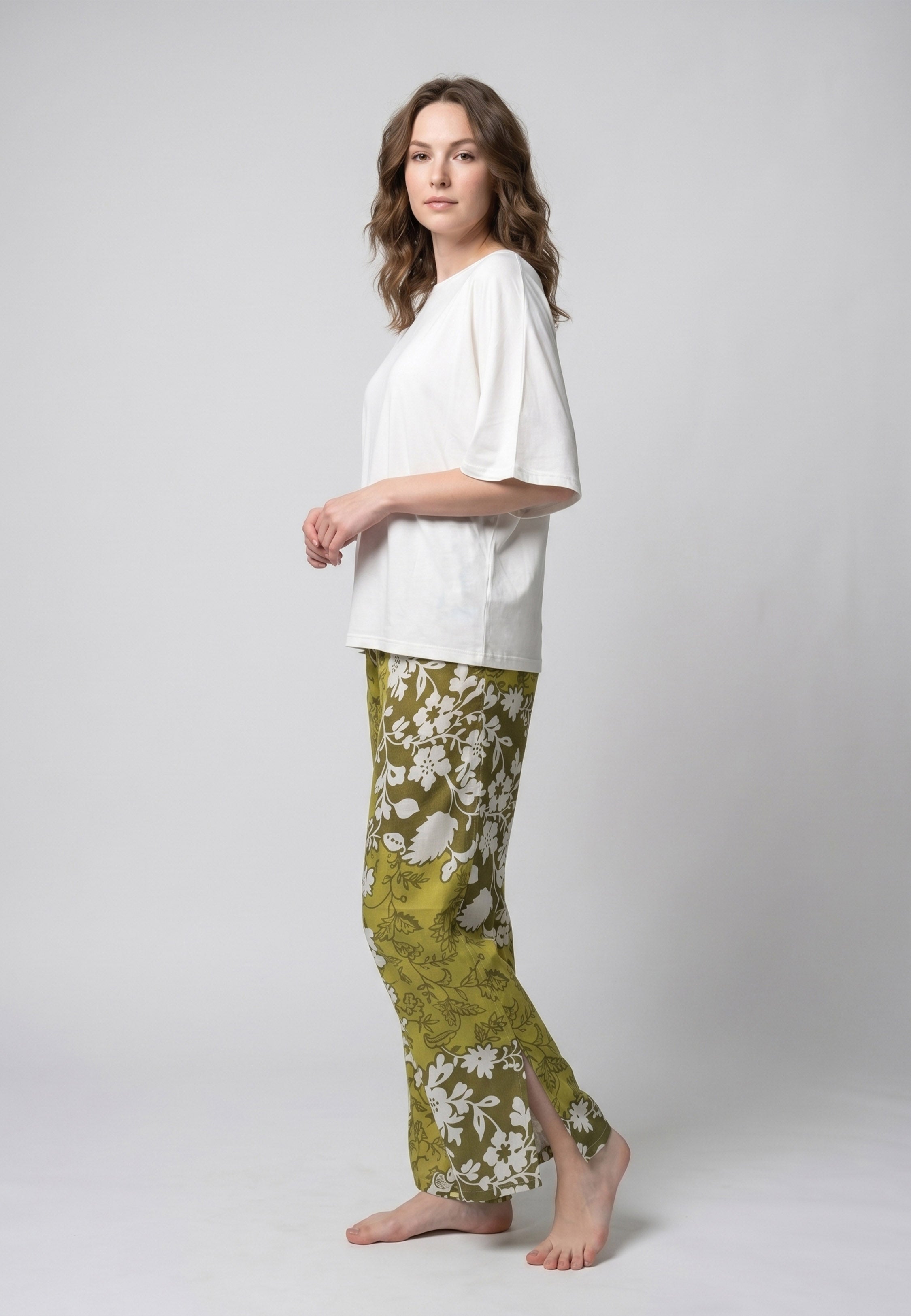 Femme portant un pyjama deux pièces t-shirt oversize uni blanc et pantalon large imprimé fleuri blanc sur fond vert kaki Rosabella Cozy Comforts