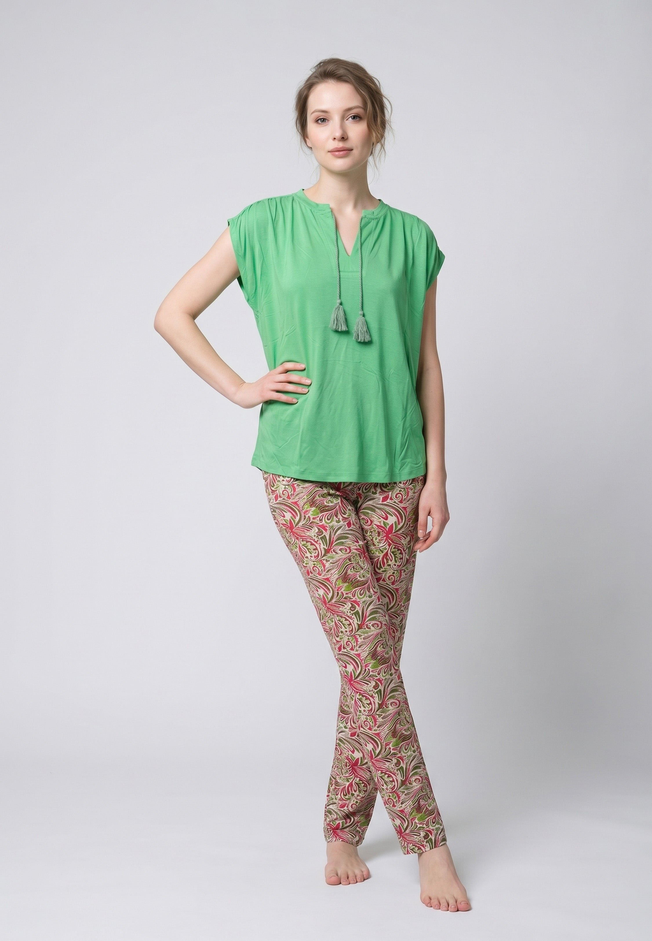Femme portant un pyjama deux pièces top vert col V avec lacets pompons et pantalon long imprimé ethnique floral multicolore Rosabella Ethnique 2