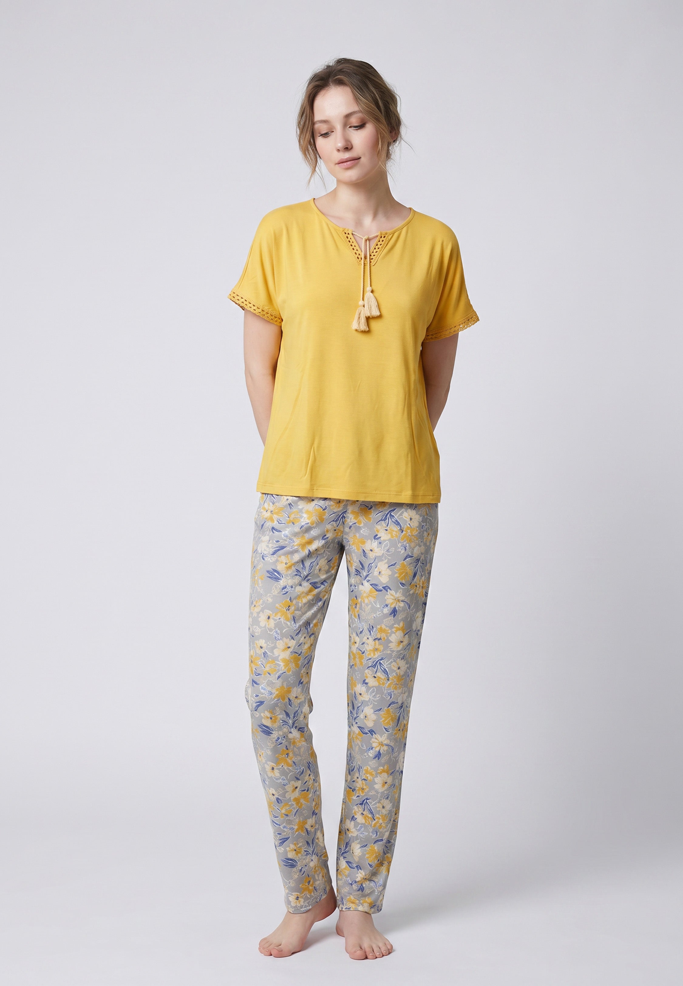 Femme portant un pyjama deux pièces top moutarde broderie et lacets pompons au col et pantalon long imprimé ethnique floral multicolore Rosabella Ethnique 2