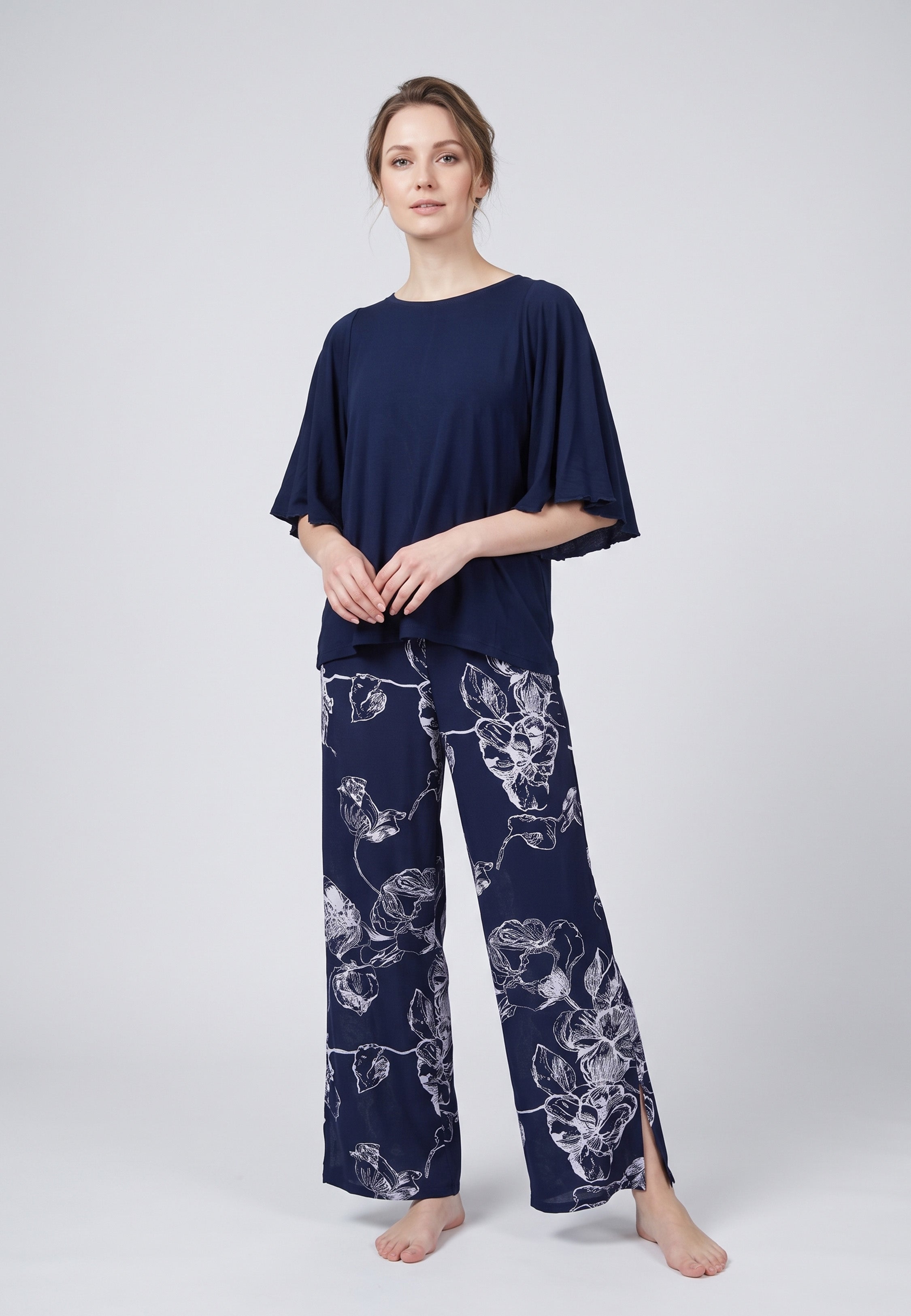 Pyjama pantalon long deux pièces T-shirt col rond bleu marine manches papillon et pantalon large fond marine imprimé grandes fleurs linéaires écru