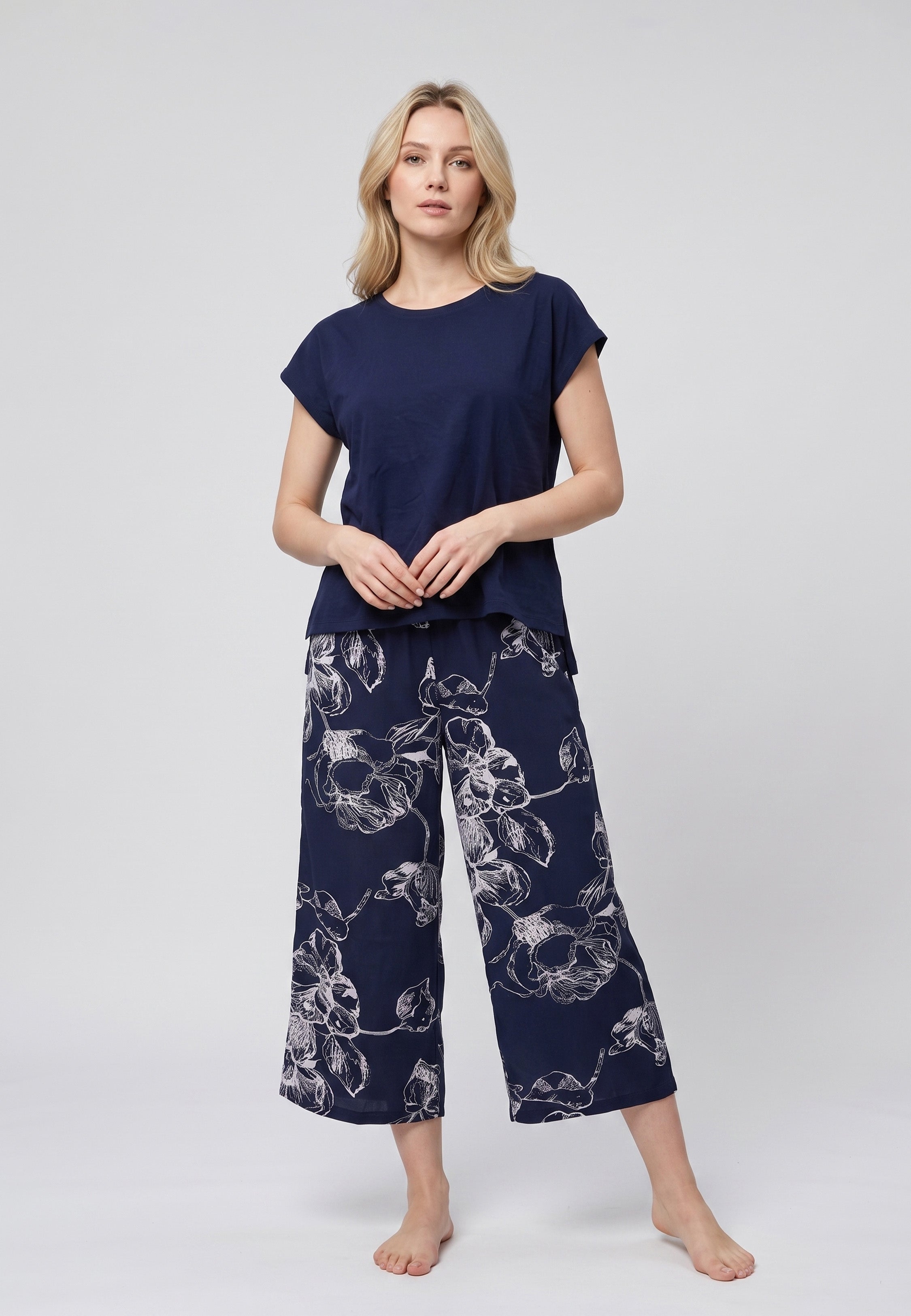 Pyjama pantacourt deux pièces T-shirt col rond bleu marine uni et pantacourt large fond marine imprimé grandes fleurs botaniques écru