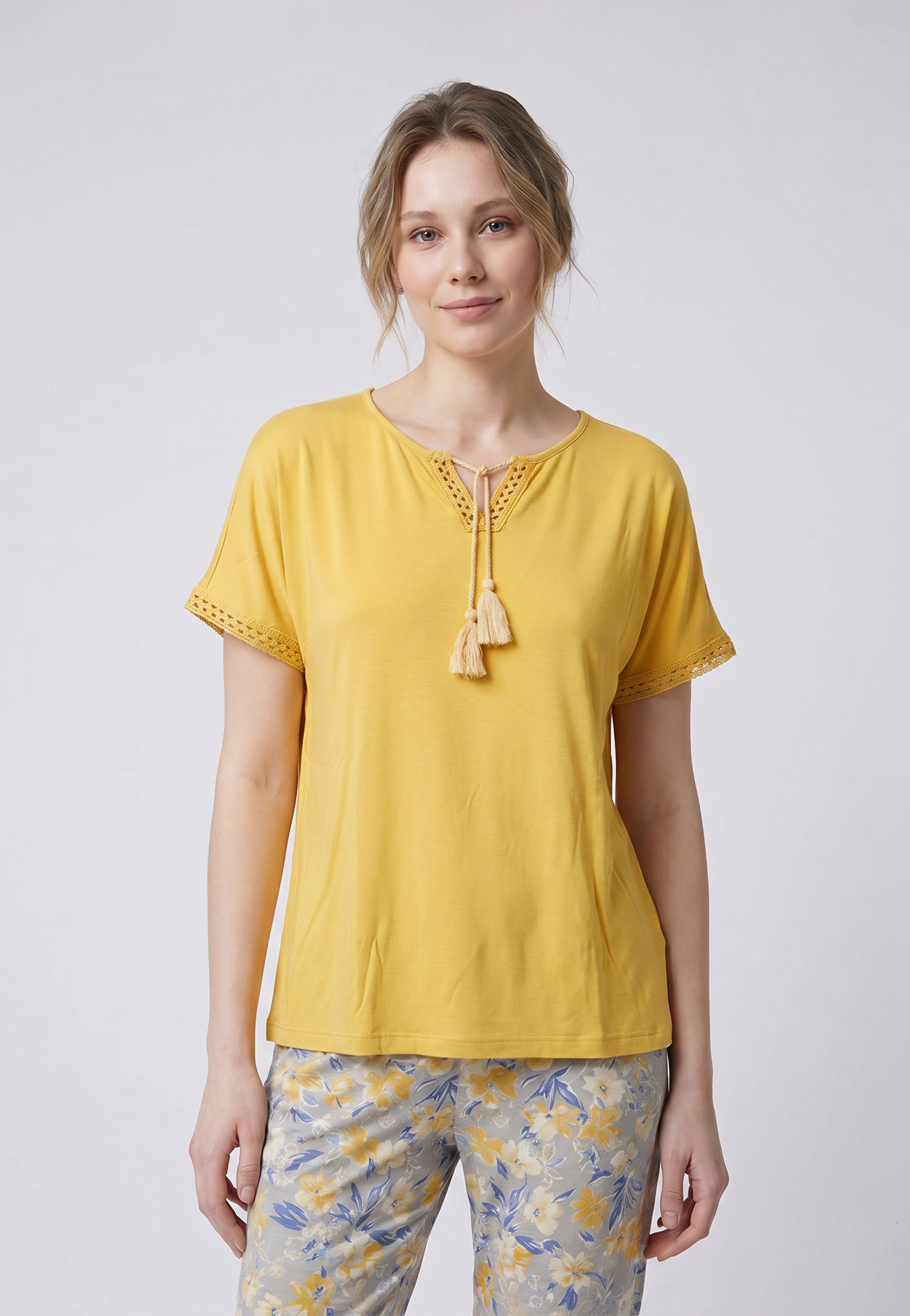 Femme portant un pyjama deux pièces top moutarde broderie et lacets pompons au col et pantalon long imprimé ethnique floral multicolore Rosabella Ethnique 2