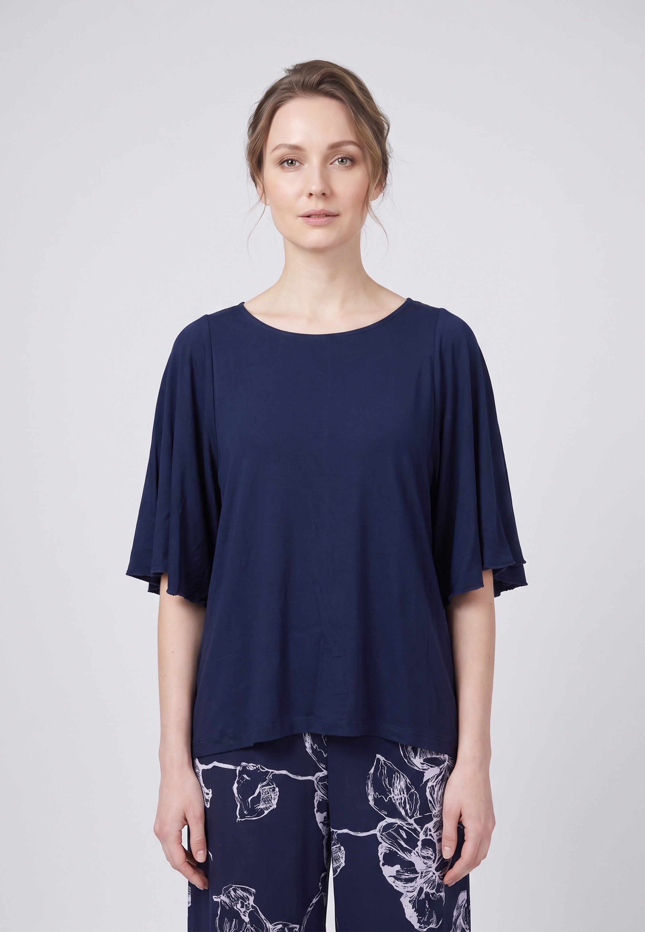 Pyjama pantalon long deux pièces T-shirt col rond bleu marine manches papillon et pantalon large fond marine imprimé grandes fleurs linéaires écru