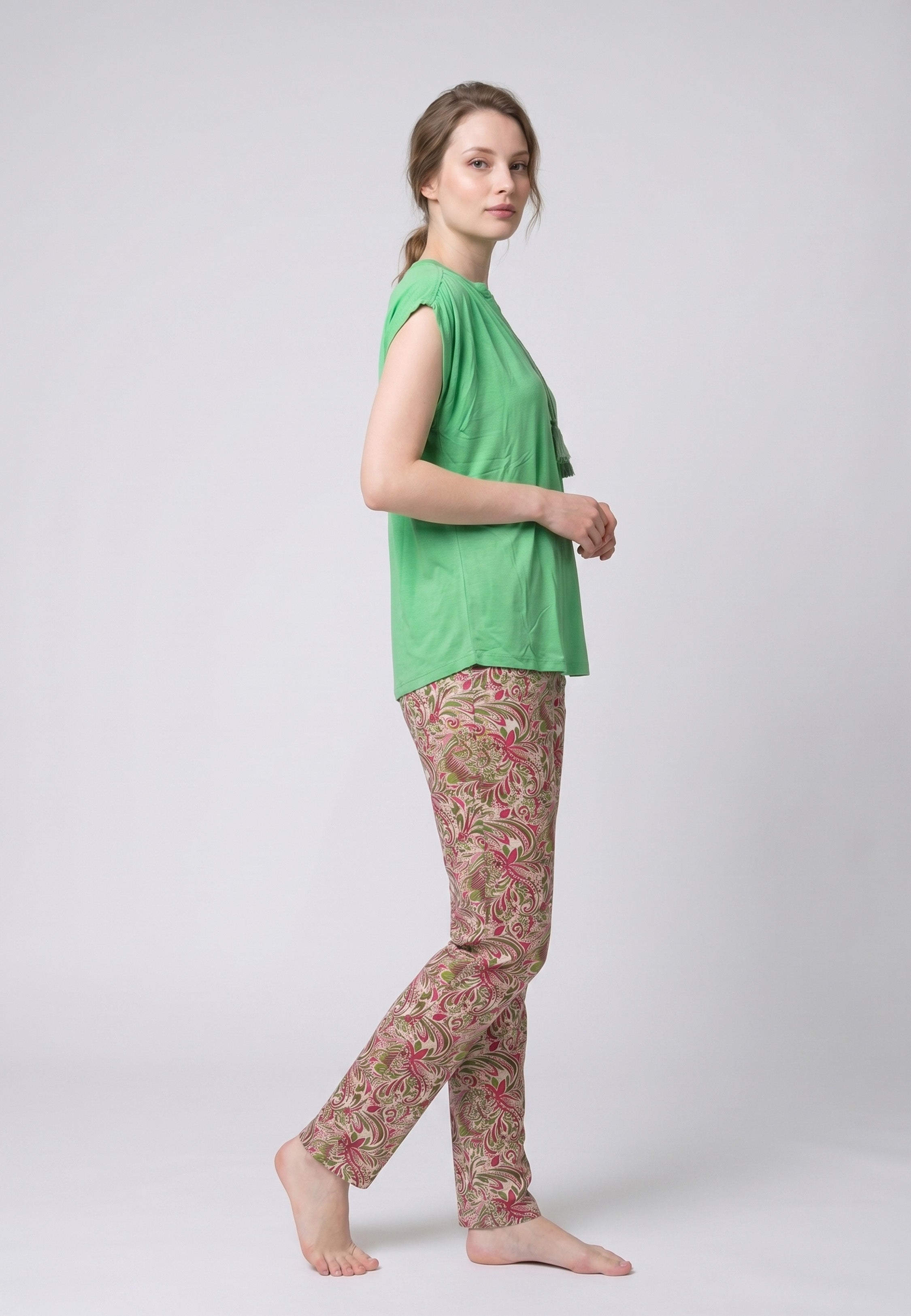 Femme portant un pyjama deux pièces top vert col V avec lacets pompons et pantalon long imprimé ethnique floral multicolore Rosabella Ethnique 2