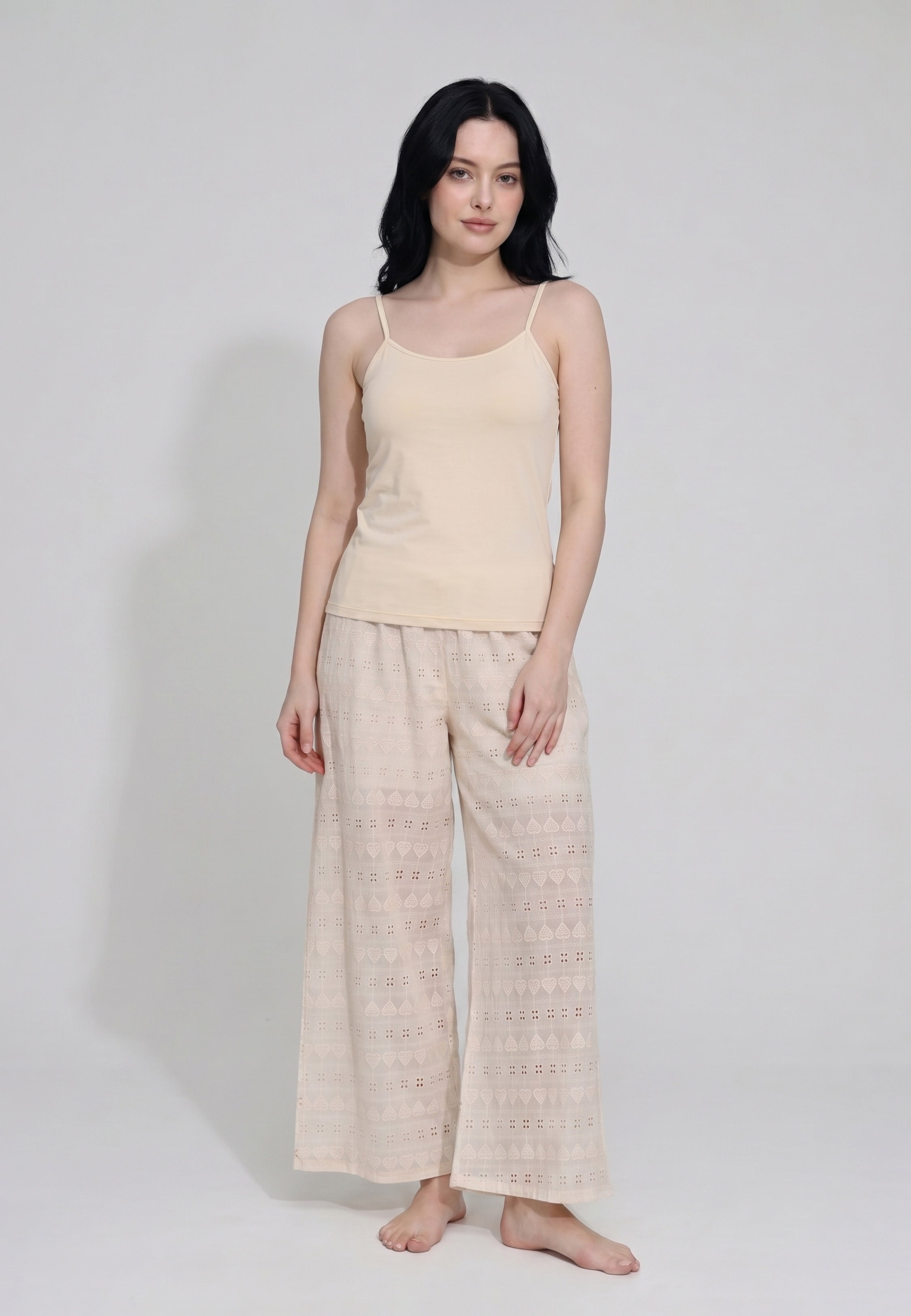 Femme portant un ensemble caraco bretelles fines coton beige sable et pantalon large broderie anglaise beige sable motifs géométriques ajourés Rosabella