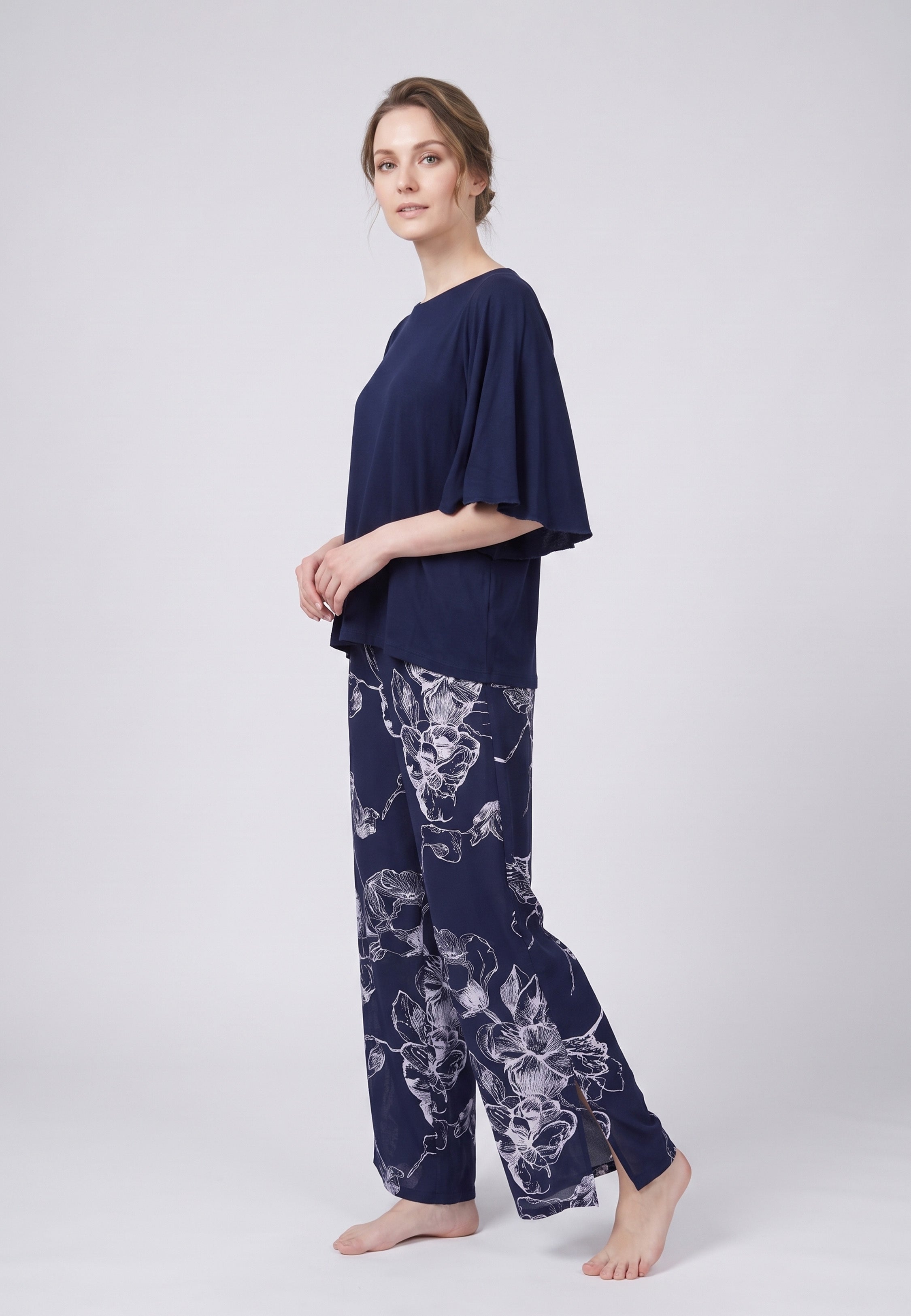 Pyjama pantalon long deux pièces T-shirt col rond bleu marine manches papillon et pantalon large fond marine imprimé grandes fleurs linéaires écru