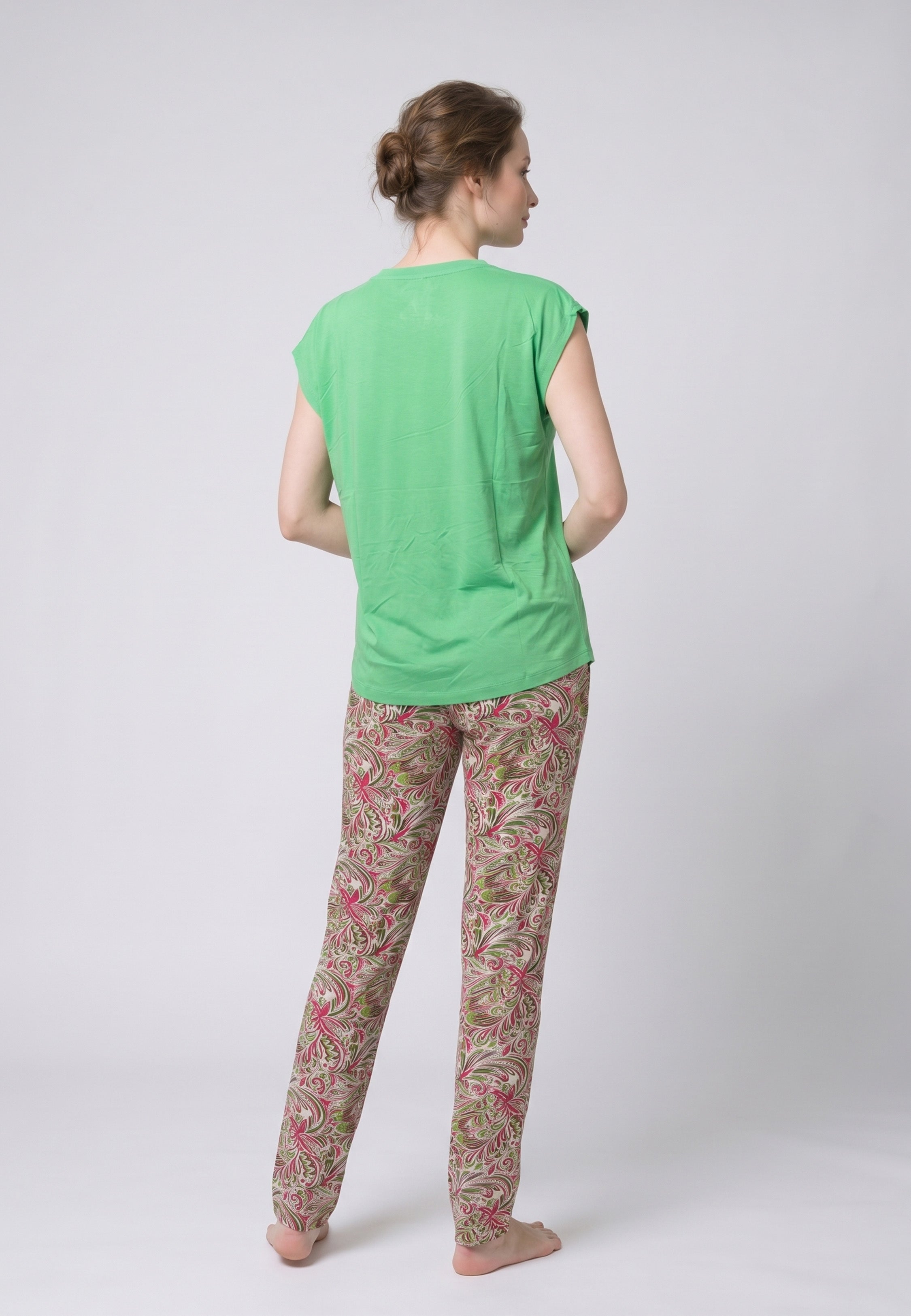 Femme portant un pyjama deux pièces top vert col V avec lacets pompons et pantalon long imprimé ethnique floral multicolore Rosabella Ethnique 2