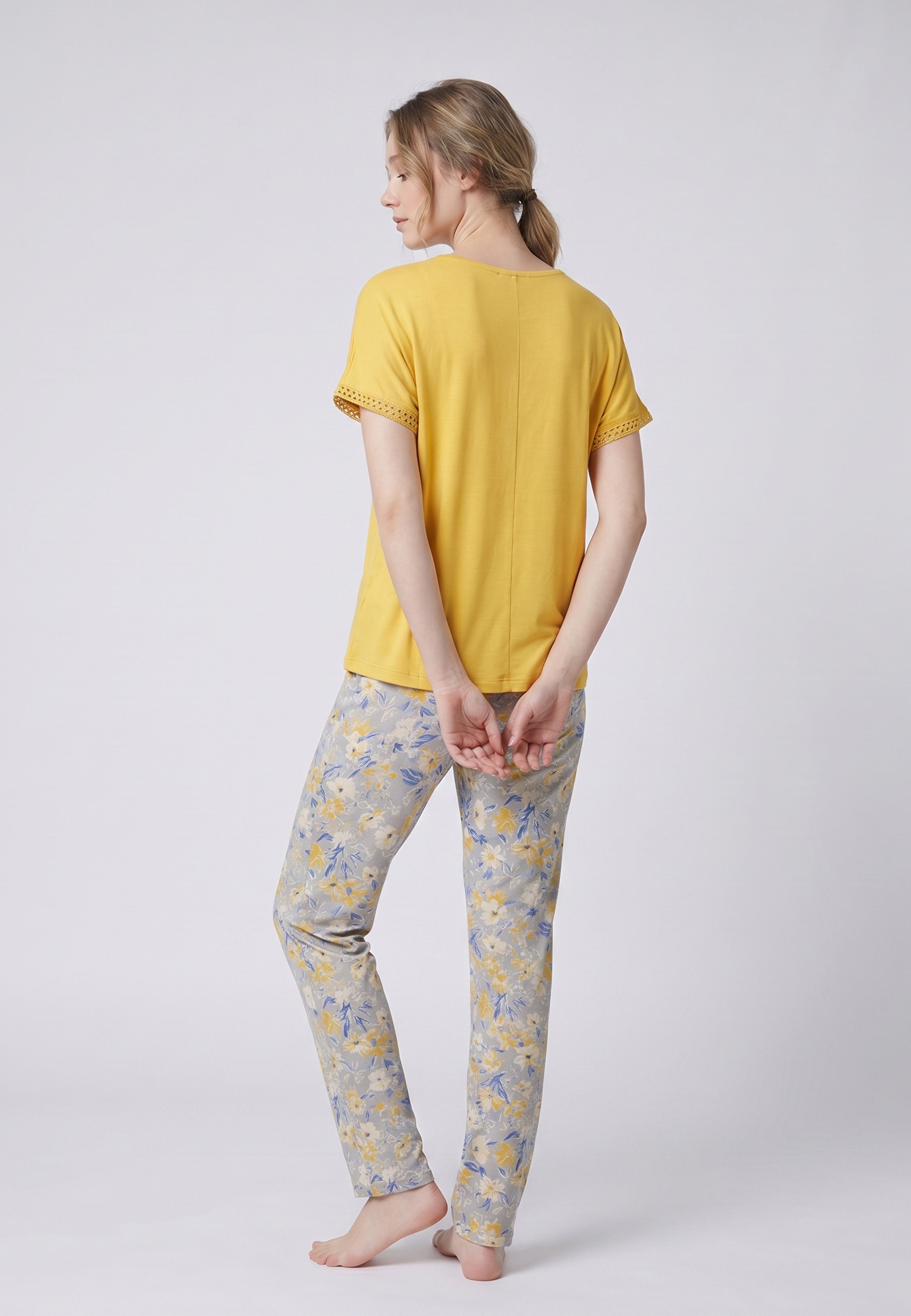 Femme portant un pyjama deux pièces top moutarde broderie et lacets pompons au col et pantalon long imprimé ethnique floral multicolore Rosabella Ethnique 2