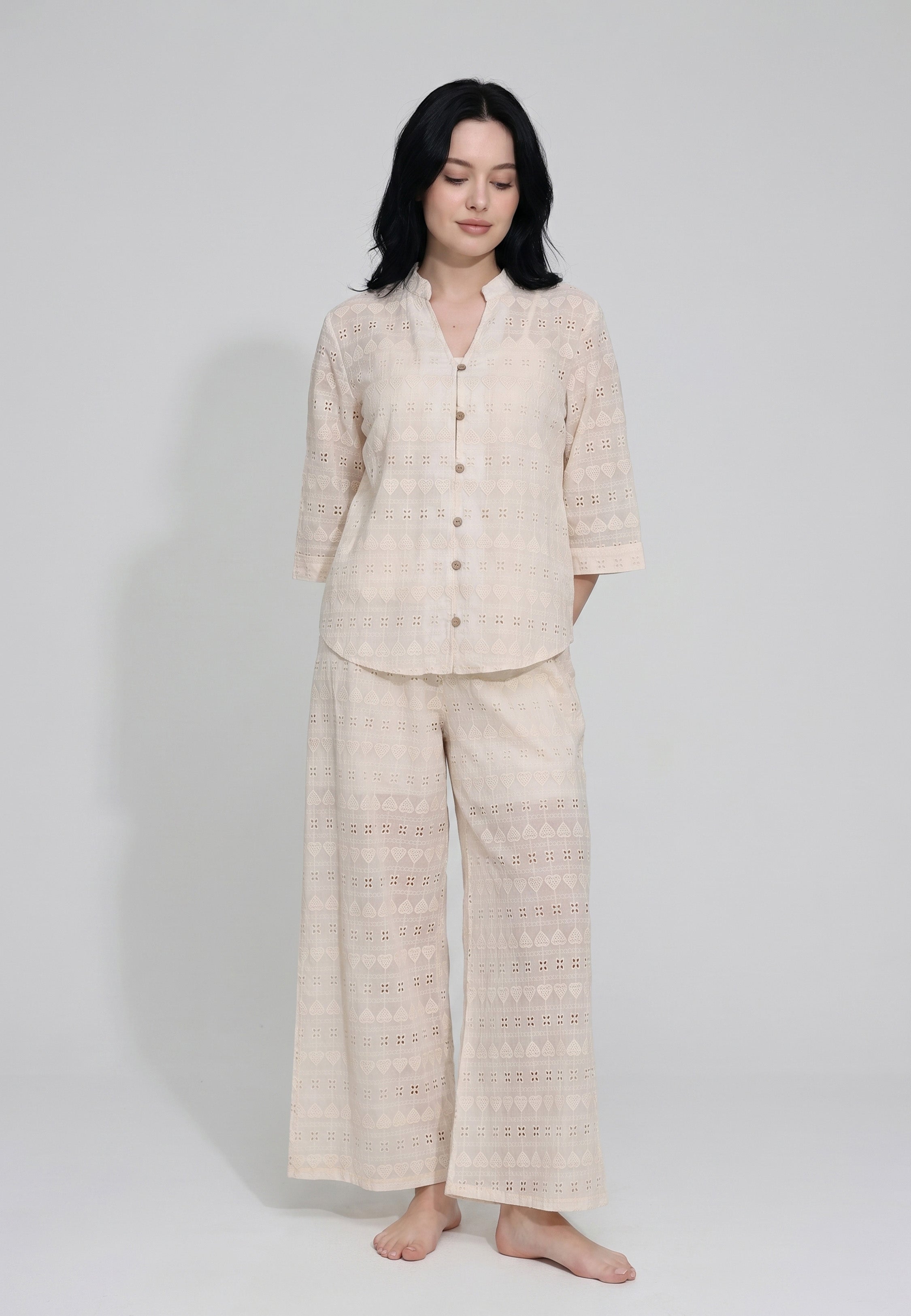 Femme portant un ensemble caraco bretelles fines coton beige sable et pantalon large broderie anglaise beige sable motifs géométriques ajourés Rosabella