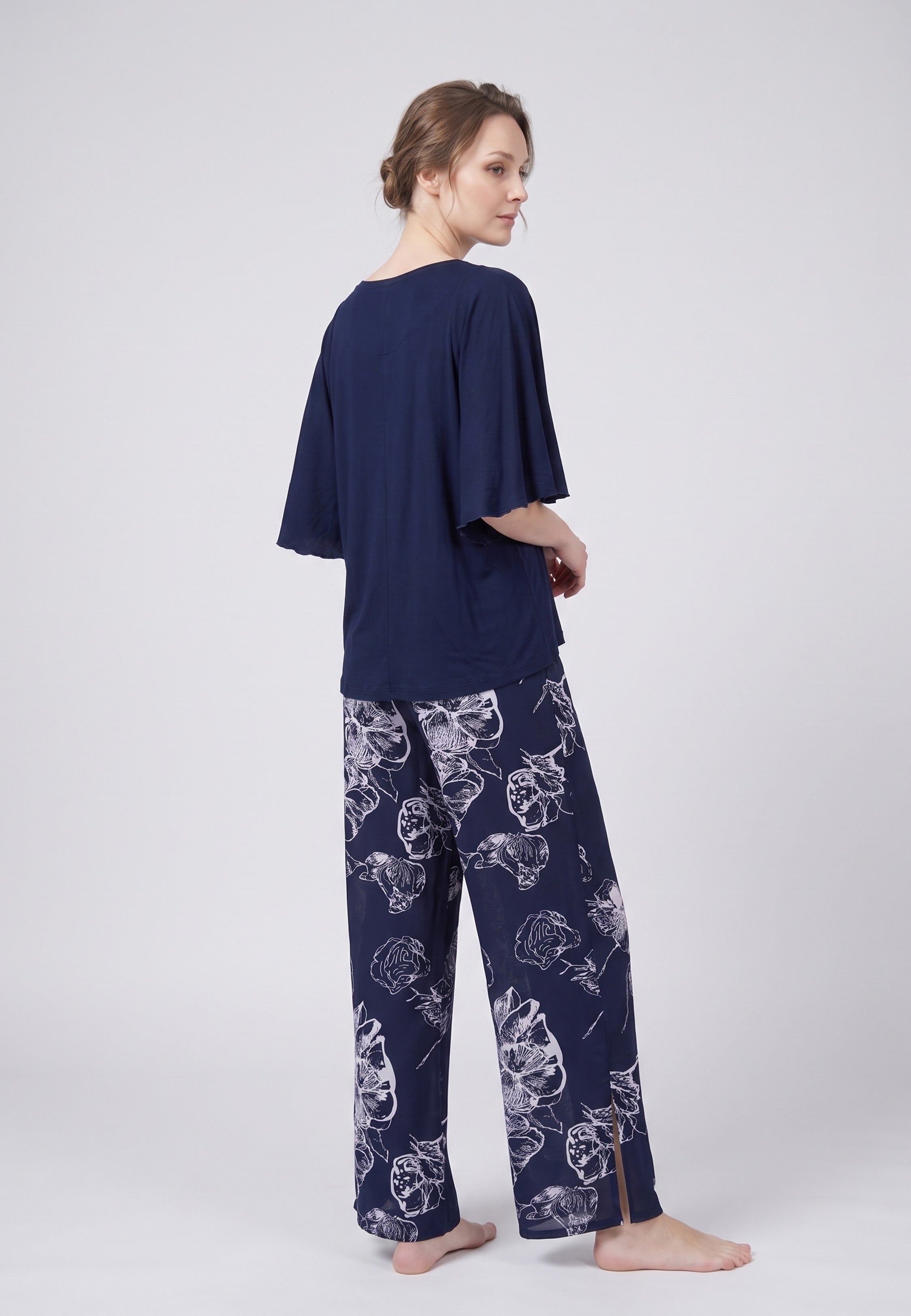 Pyjama pantalon long deux pièces T-shirt col rond bleu marine manches papillon et pantalon large fond marine imprimé grandes fleurs linéaires écru