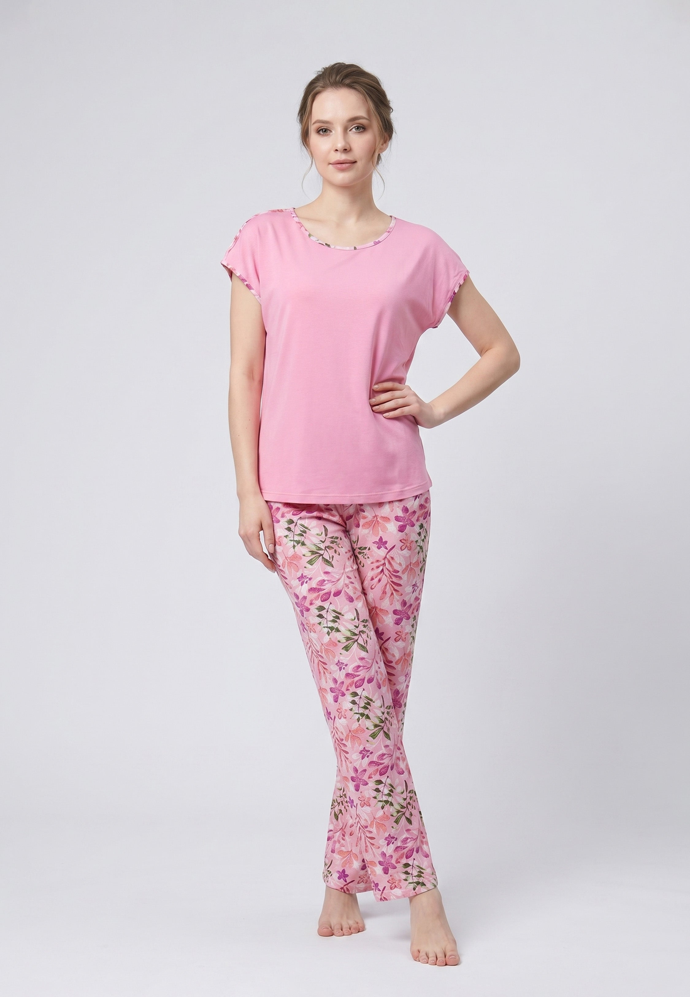 Femme portant un pyjama deux pièces haut uni rose et pantalon à imprimé floral rose et violet