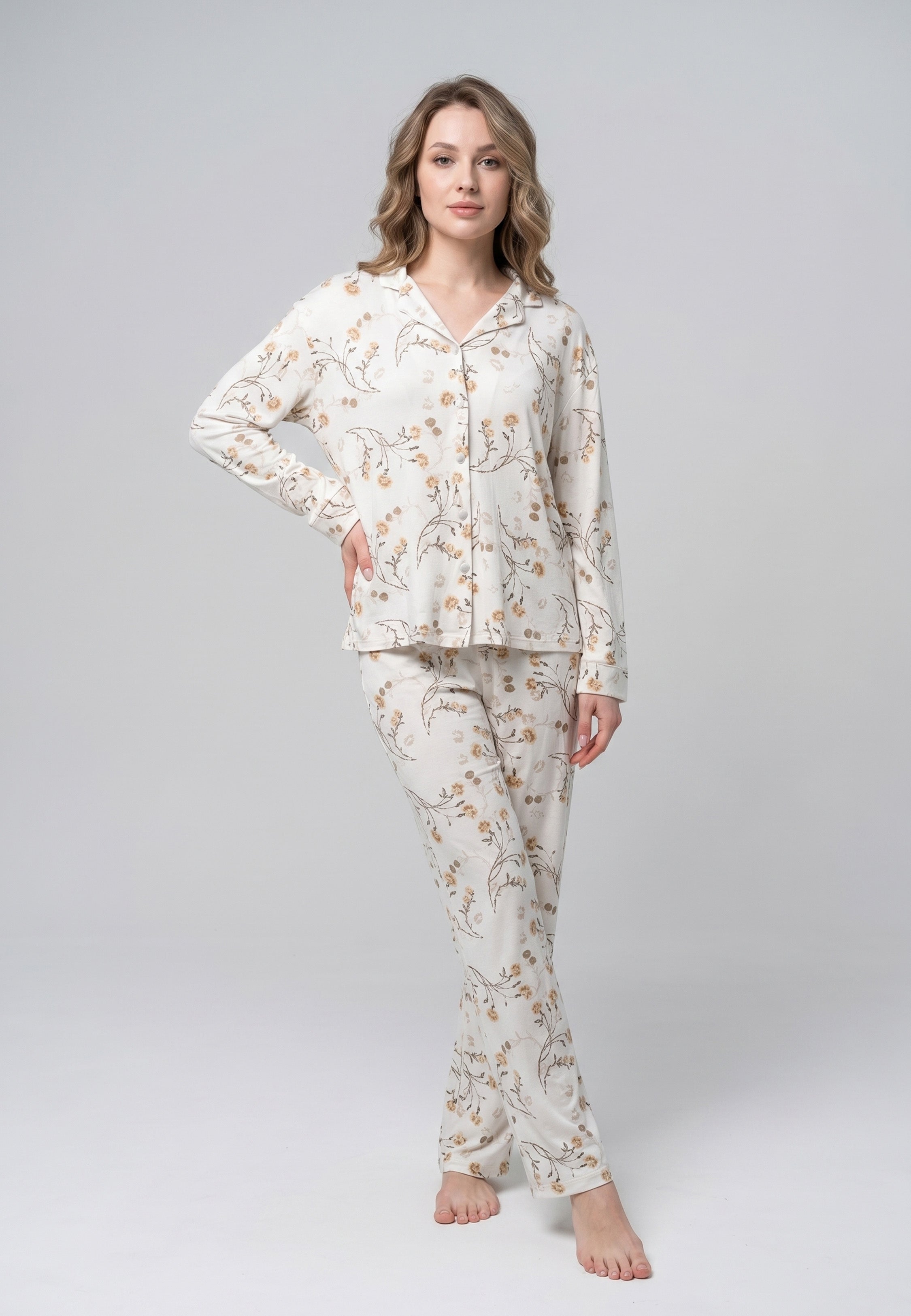 Femme portant un pyjama deux pièces chemise boutonnée col pyjama manches longues imprimé fleuri fleurs sauvages beige et doré sur fond crème et pantalon droit assorti Rosabella Soft Bloom