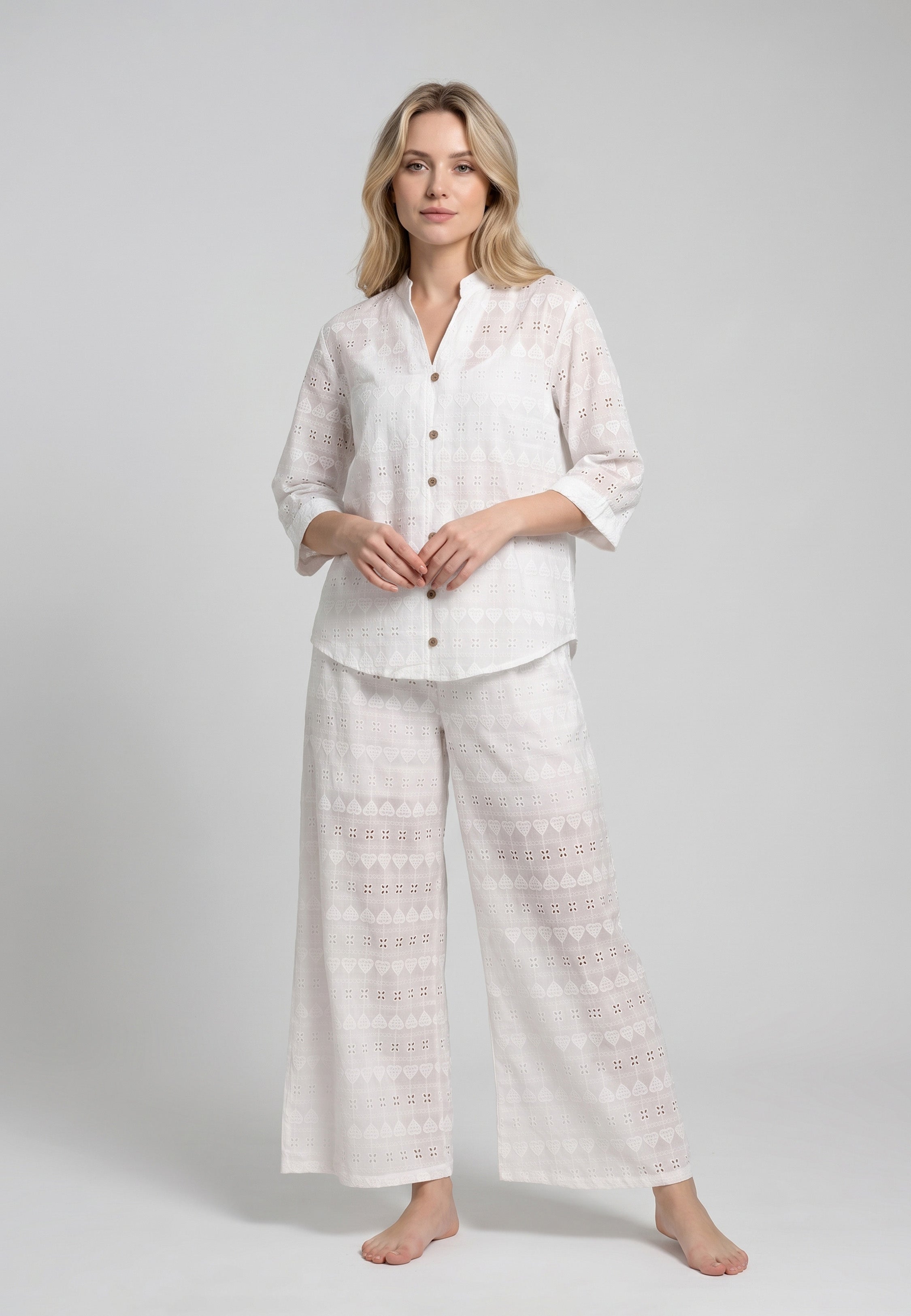 Femme portant un ensemble caraco bretelles fines coton blanc et pantalon large broderie anglaise blanche motifs géométriques ajourés Rosabella
