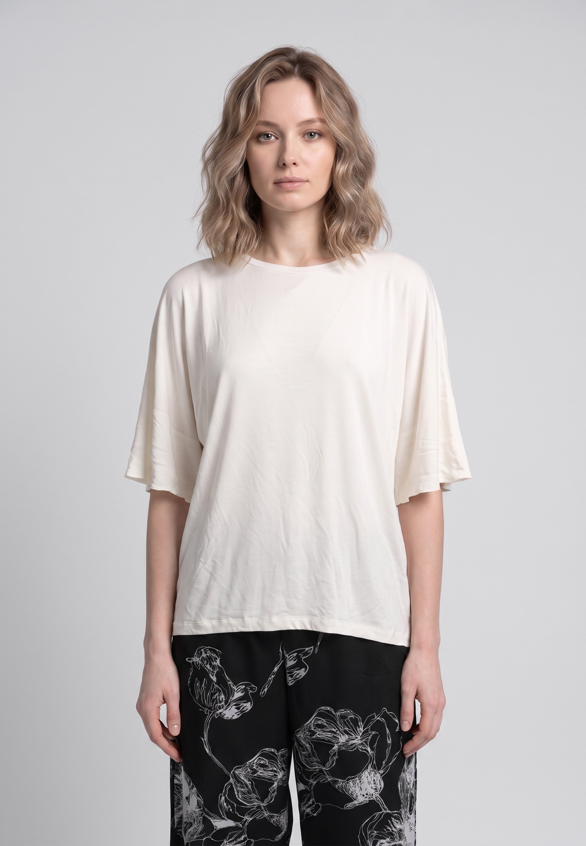 Pyjama pantalon long deux pièces T-shirt col rond écru manches évasées et pantalon large fond noir imprimé grandes fleurs botaniques écru