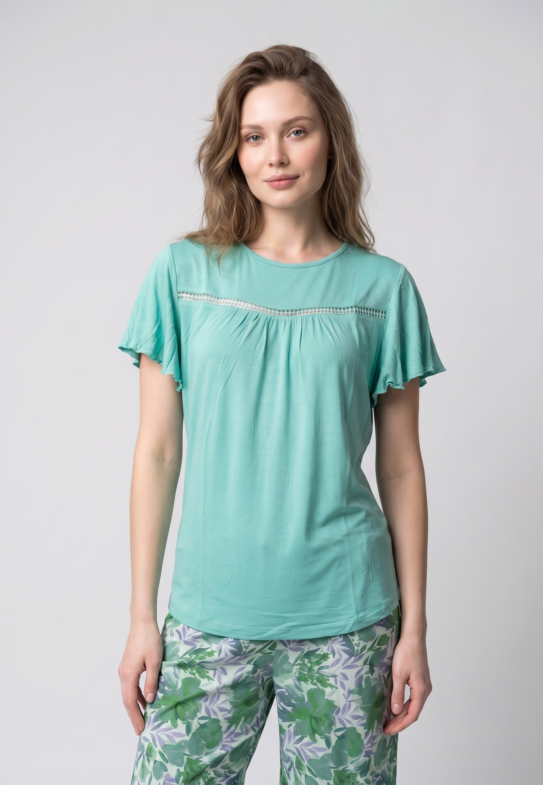 Femme portant un pyjama deux pièces t-shirt vert clair manches volantées broderie anglaise et pantalon large grand imprimé floral coloré Rosabella Juliet Rose