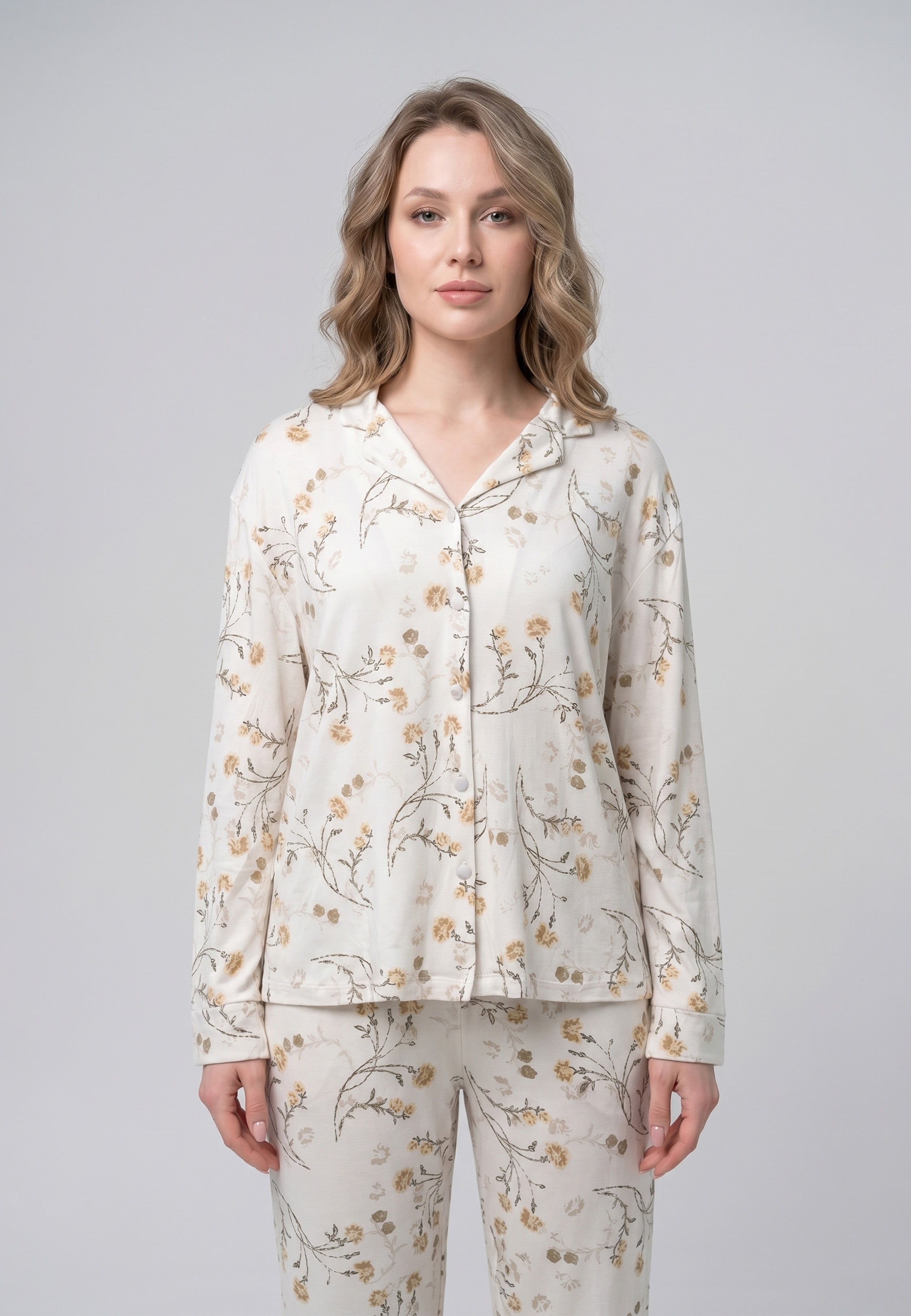 Femme portant un pyjama deux pièces chemise boutonnée col pyjama manches longues imprimé fleuri fleurs sauvages beige et doré sur fond crème et pantalon droit assorti Rosabella Soft Bloom