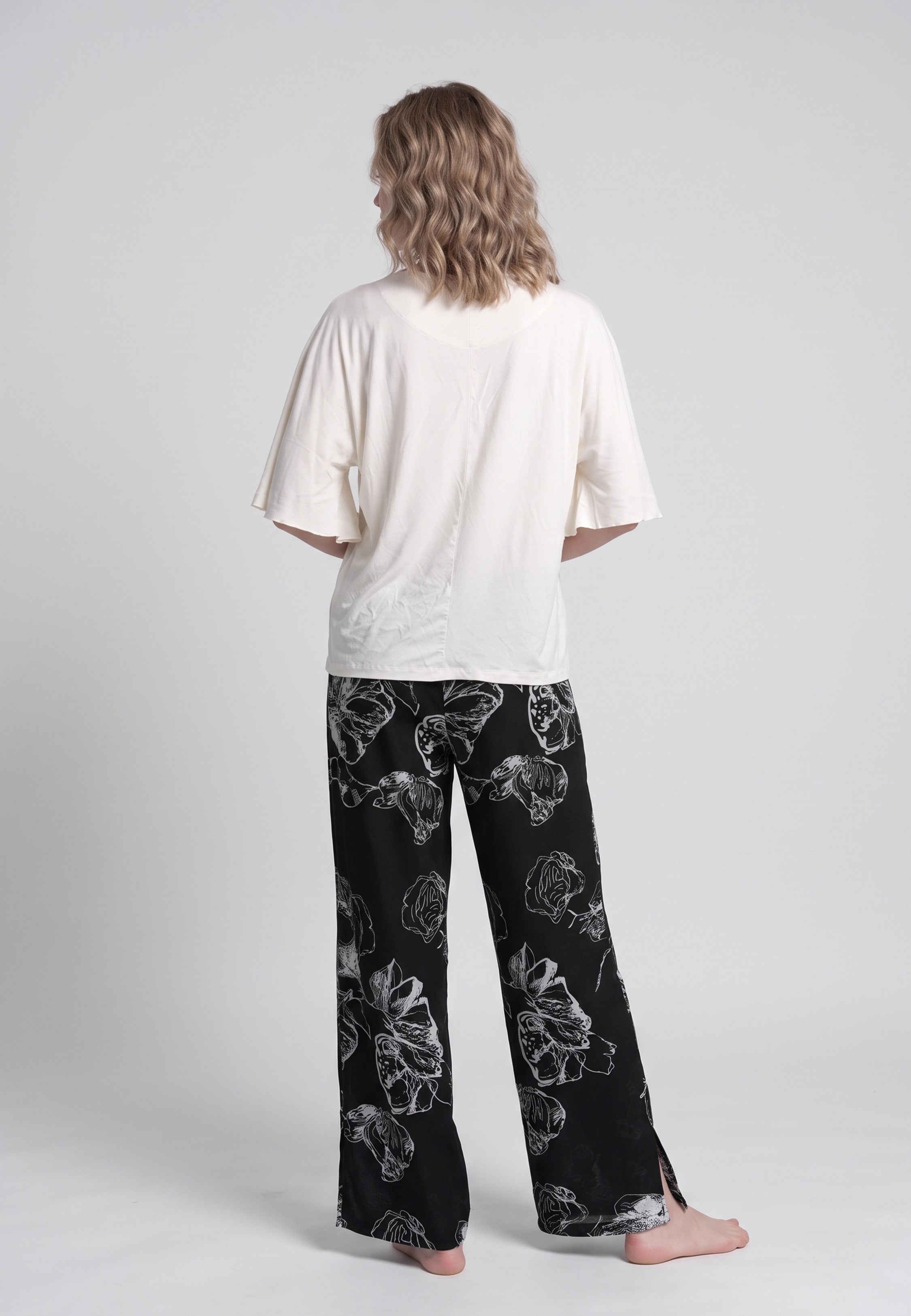 Pyjama pantalon long deux pièces T-shirt col rond écru manches évasées et pantalon large fond noir imprimé grandes fleurs botaniques écru