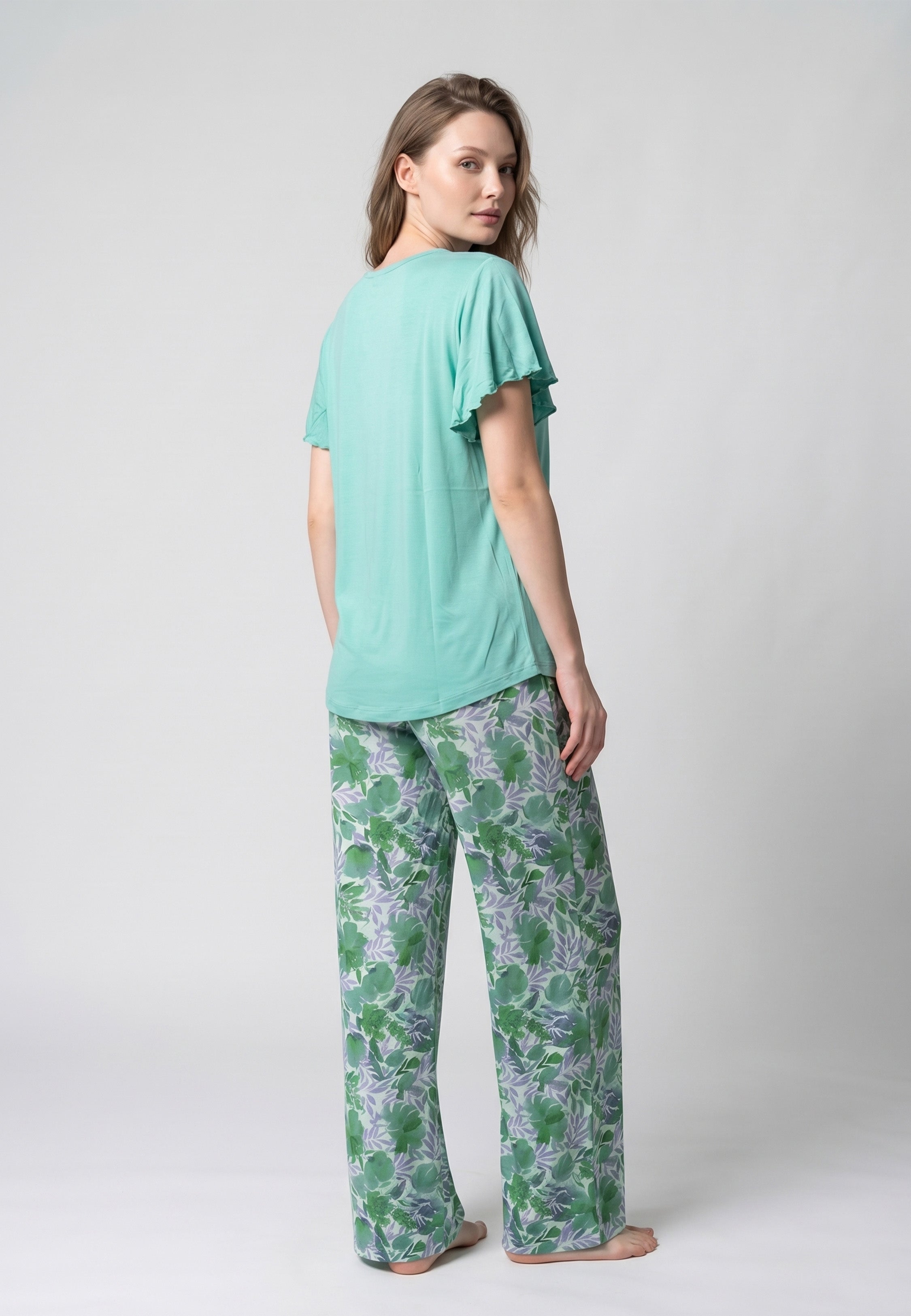 Femme portant un pyjama deux pièces t-shirt vert clair manches volantées broderie anglaise et pantalon large grand imprimé floral coloré Rosabella Juliet Rose