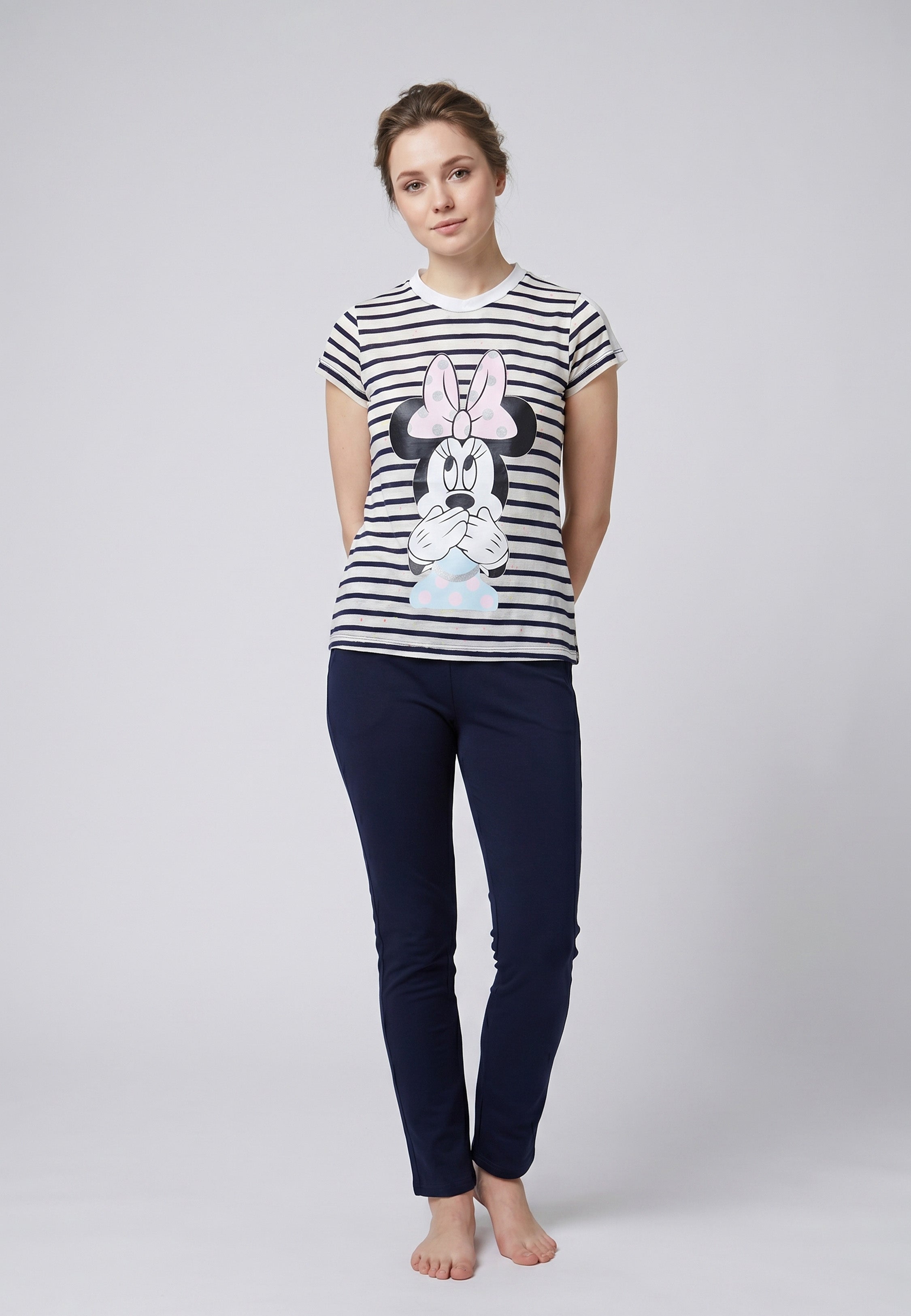 Femme portant un pyjama deux pièces rayé marine avec grand imprimé Minnie Mouse surprise et pantalon uni bleu marine