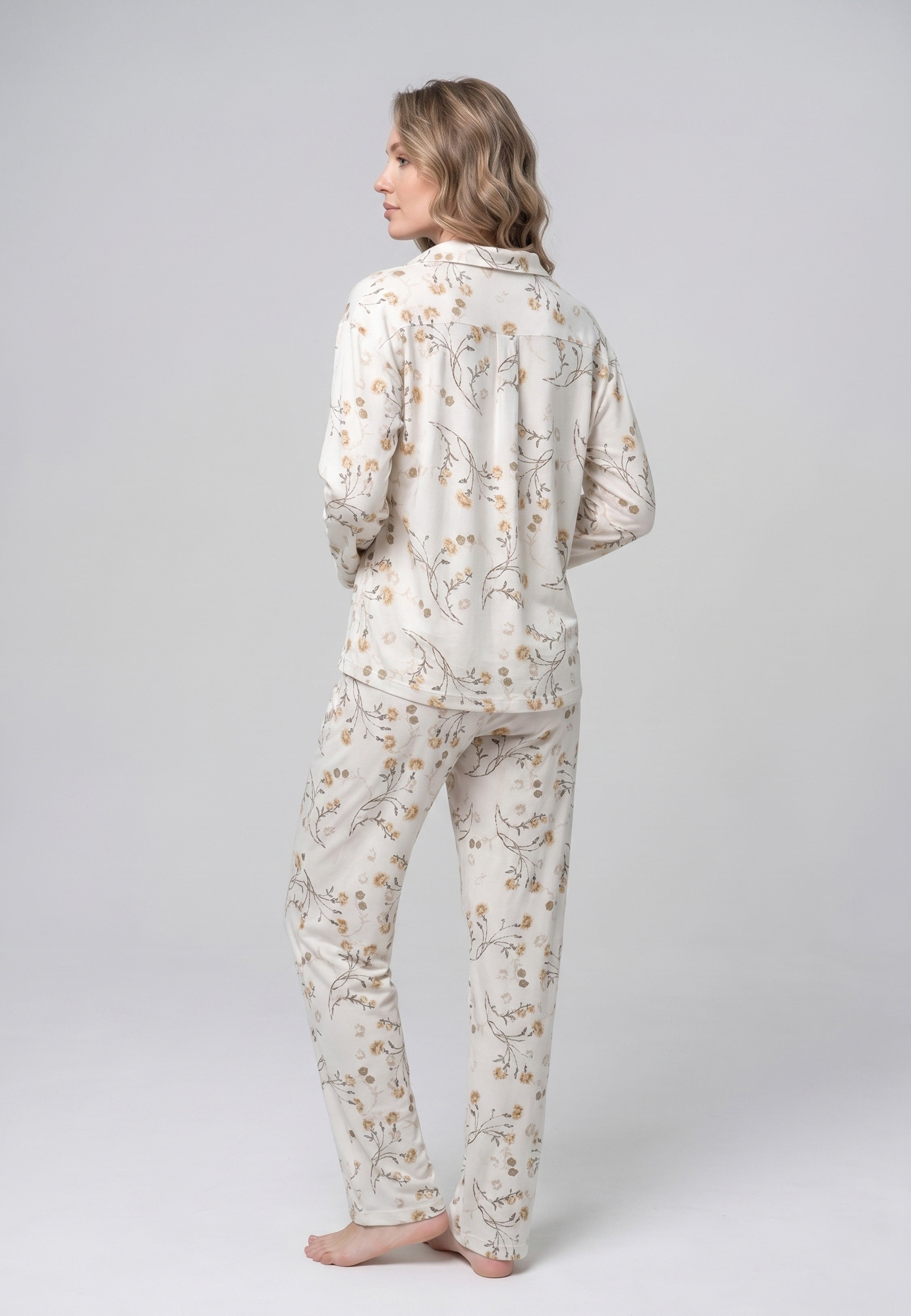 Femme portant un pyjama deux pièces chemise boutonnée col pyjama manches longues imprimé fleuri fleurs sauvages beige et doré sur fond crème et pantalon droit assorti Rosabella Soft Bloom