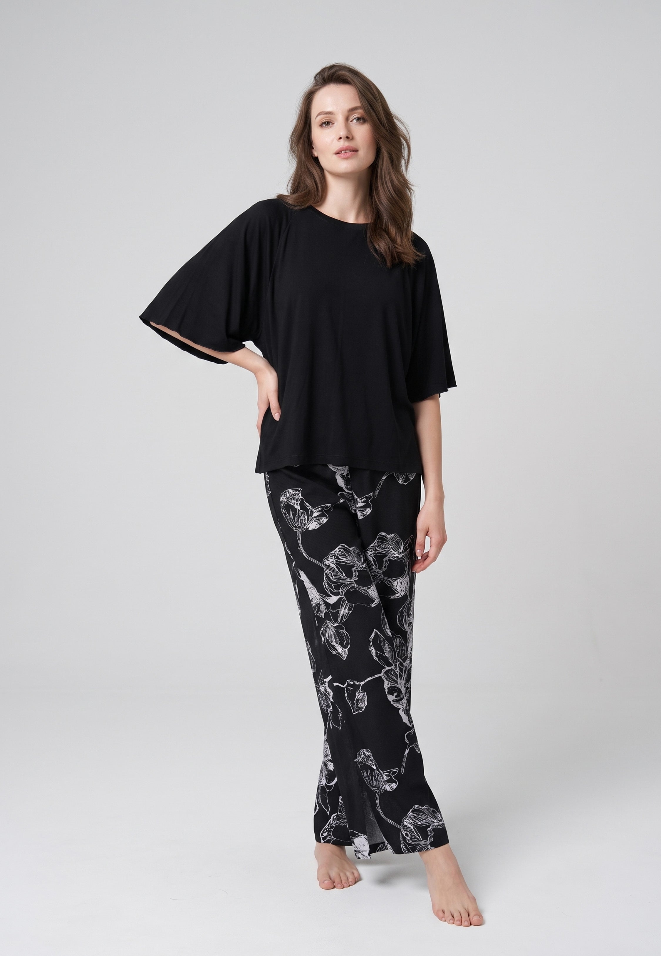 Pyjama pantalon long deux pièces T-shirt col rond noir manches papillon évasées et pantalon large fond noir imprimé grandes fleurs botaniques au trait écru